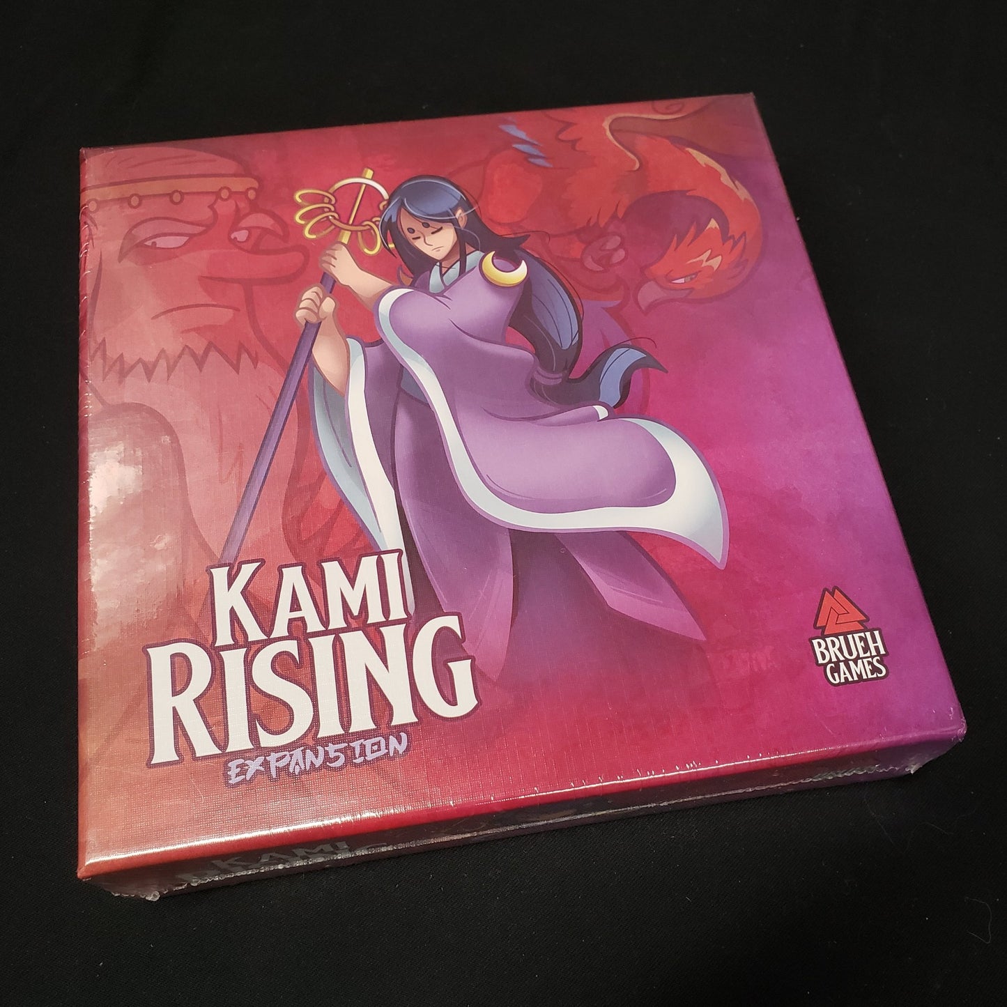 Image shows the front cover of the box of the Kami Rising expansion for the board game Night Parade of a Hunderd Yokai