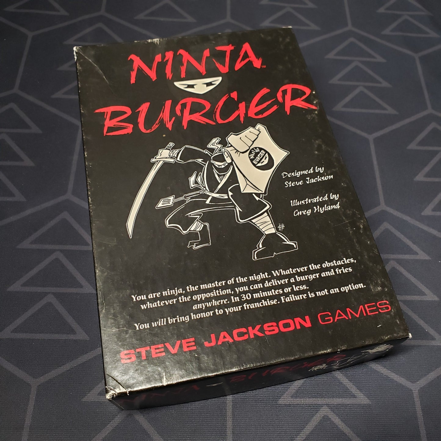 Image shows the front cover of the box of the Ninja Burger card game