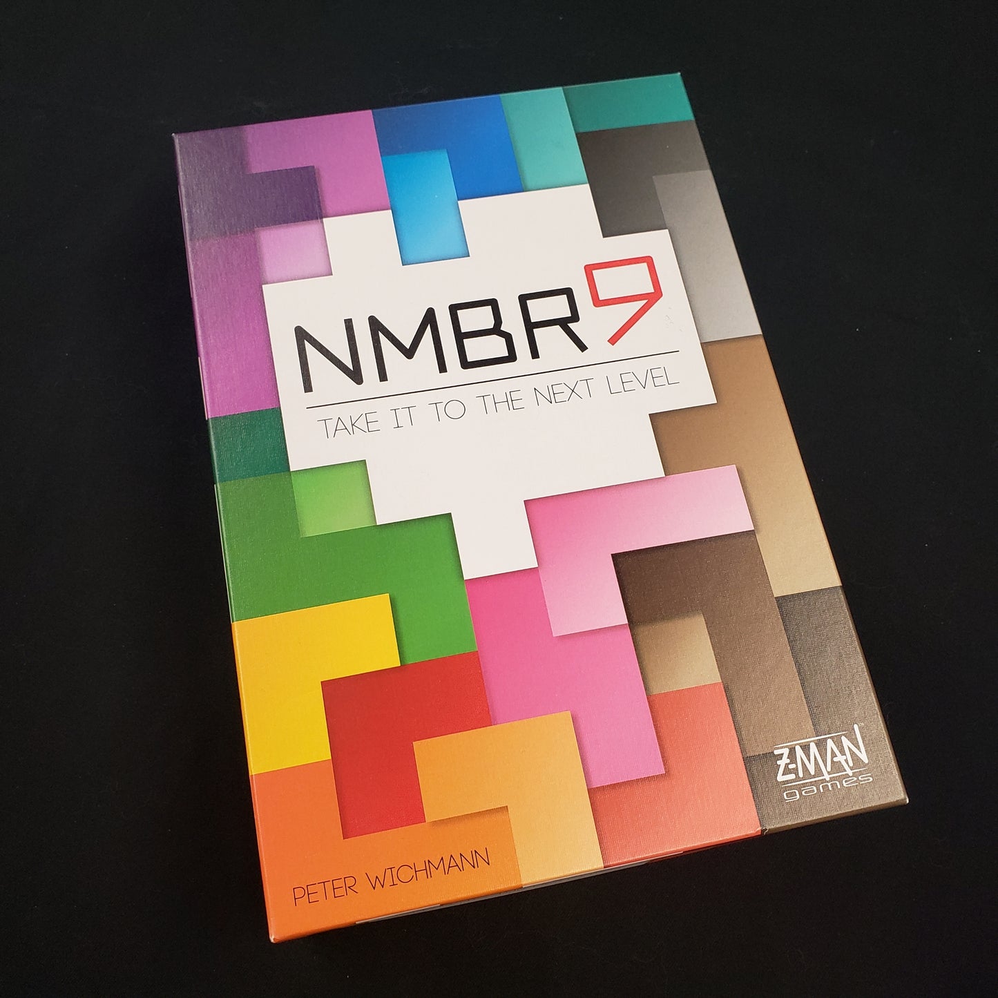 Image shows the front cover of the box of the NMBR 9 board game