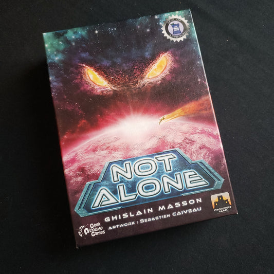 Image shows the front cover of the box of the Not Alone card game