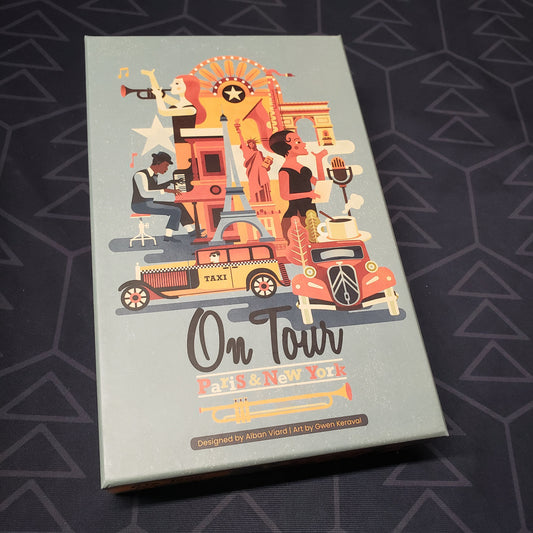 Image shows the front cover of the box for the On Tour: Paris & New York board game