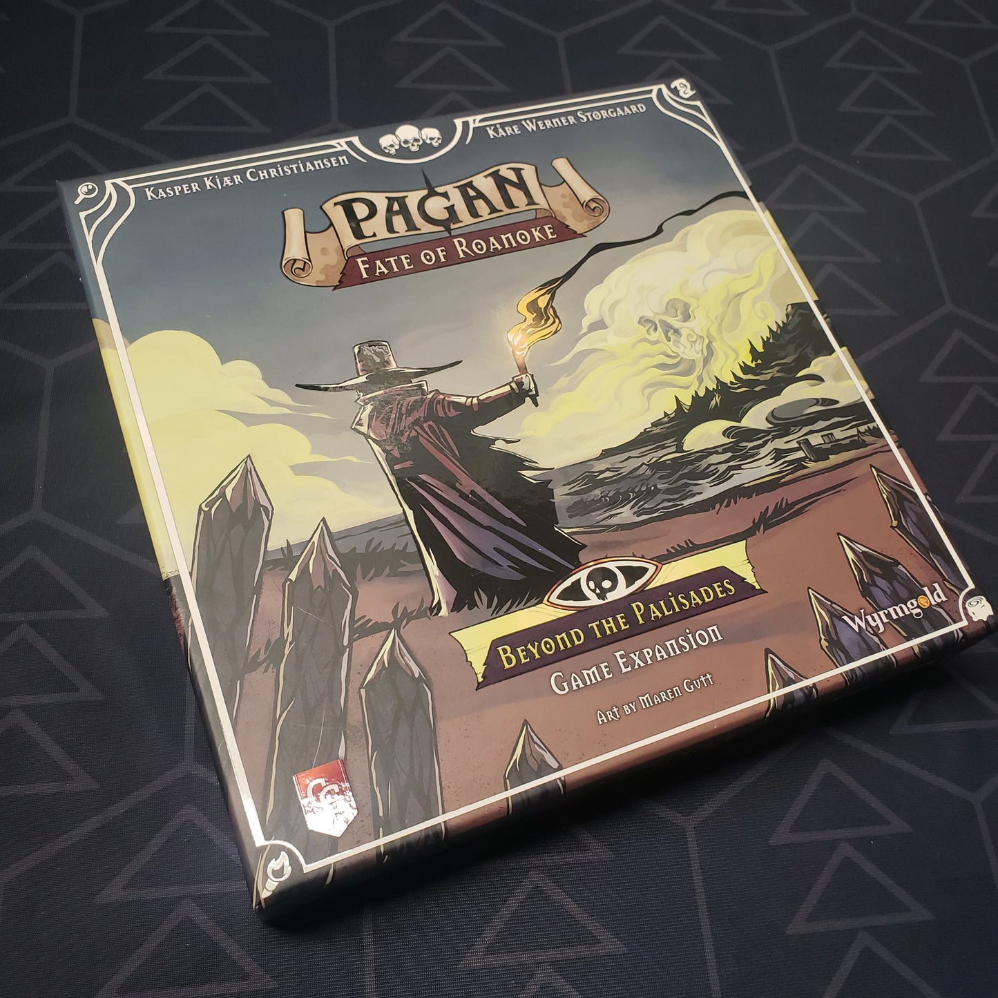 Image shows the front cover of the box of the Beyond the Palisades expansion for the card game Pagan: Fate of Roanoke