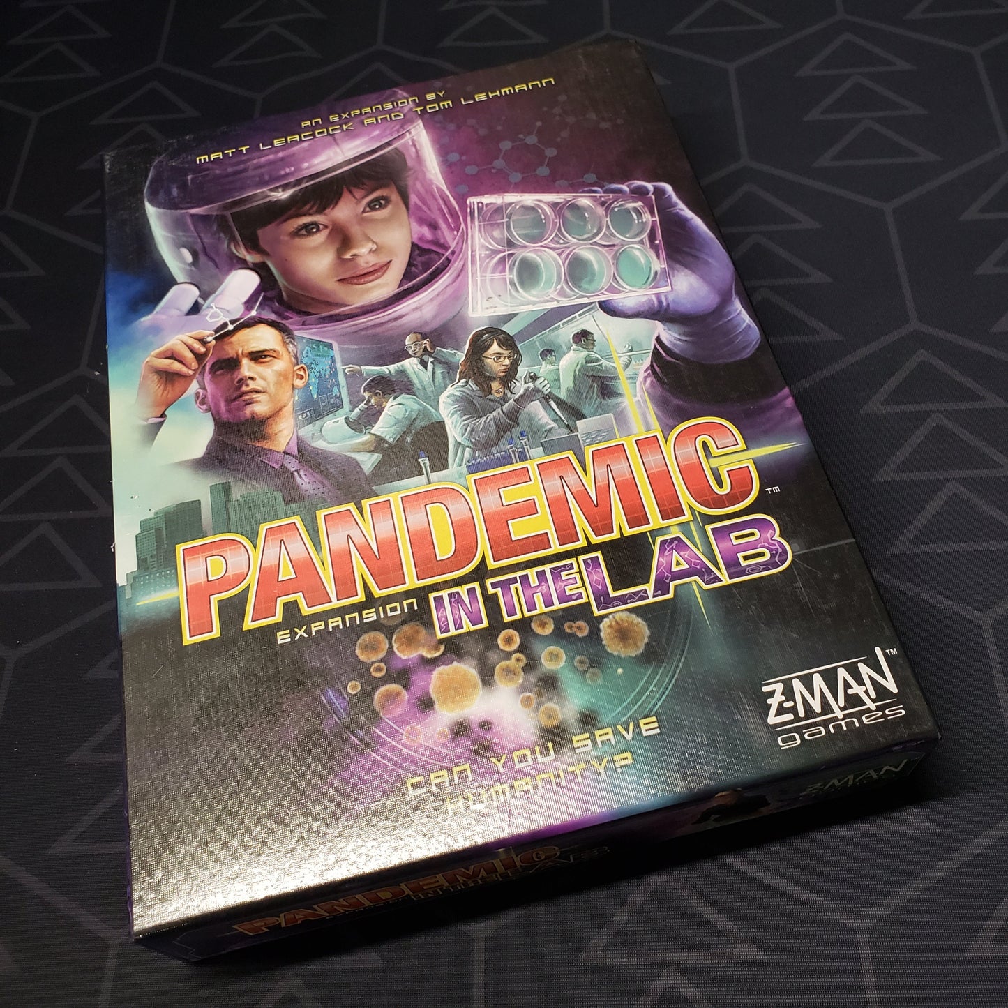 Image shows the front cover of the box of the In The Lab expansion for the board game Pandemic