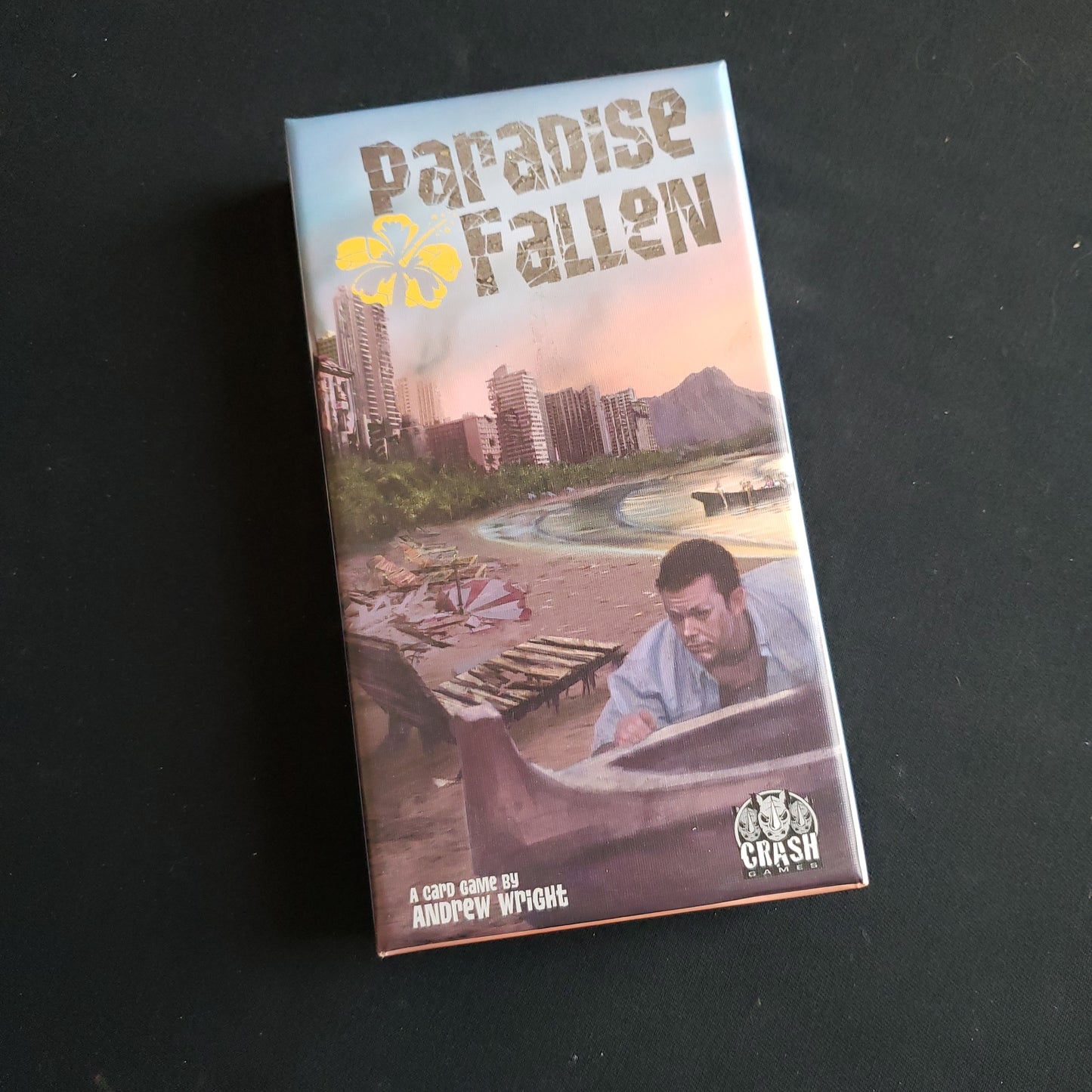 Image shows the front cover of the box of the Paradise Fallen card game