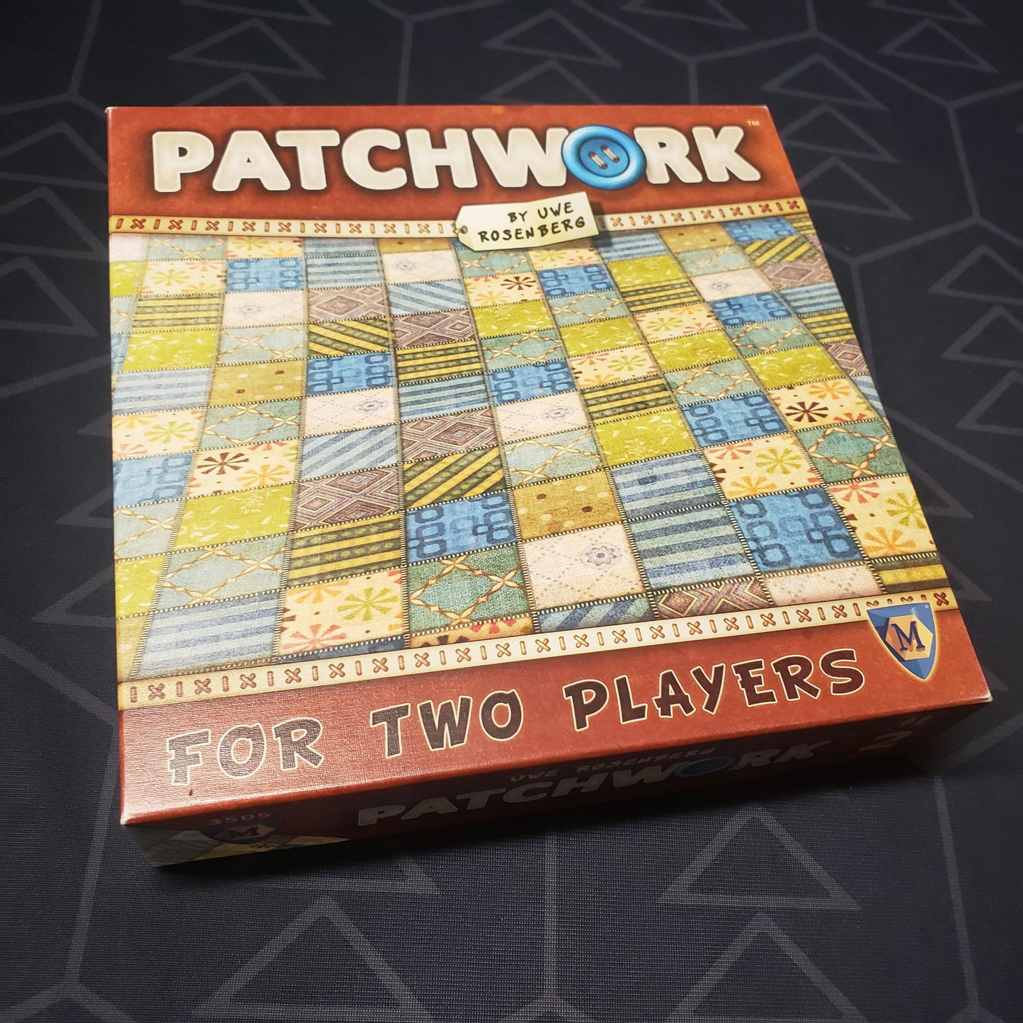 Image shows the front cover of the box of the Patchwork board game