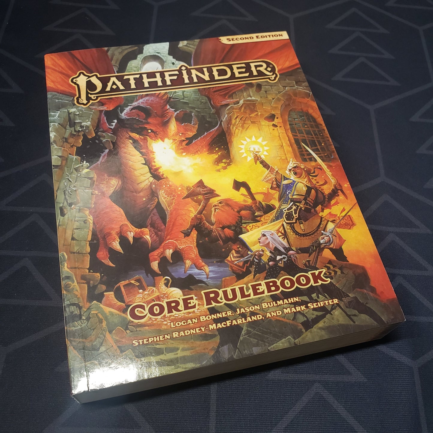 Image shows the front cover of the pocket edition core rulebook for the roleplaying game Pathfinder 2E