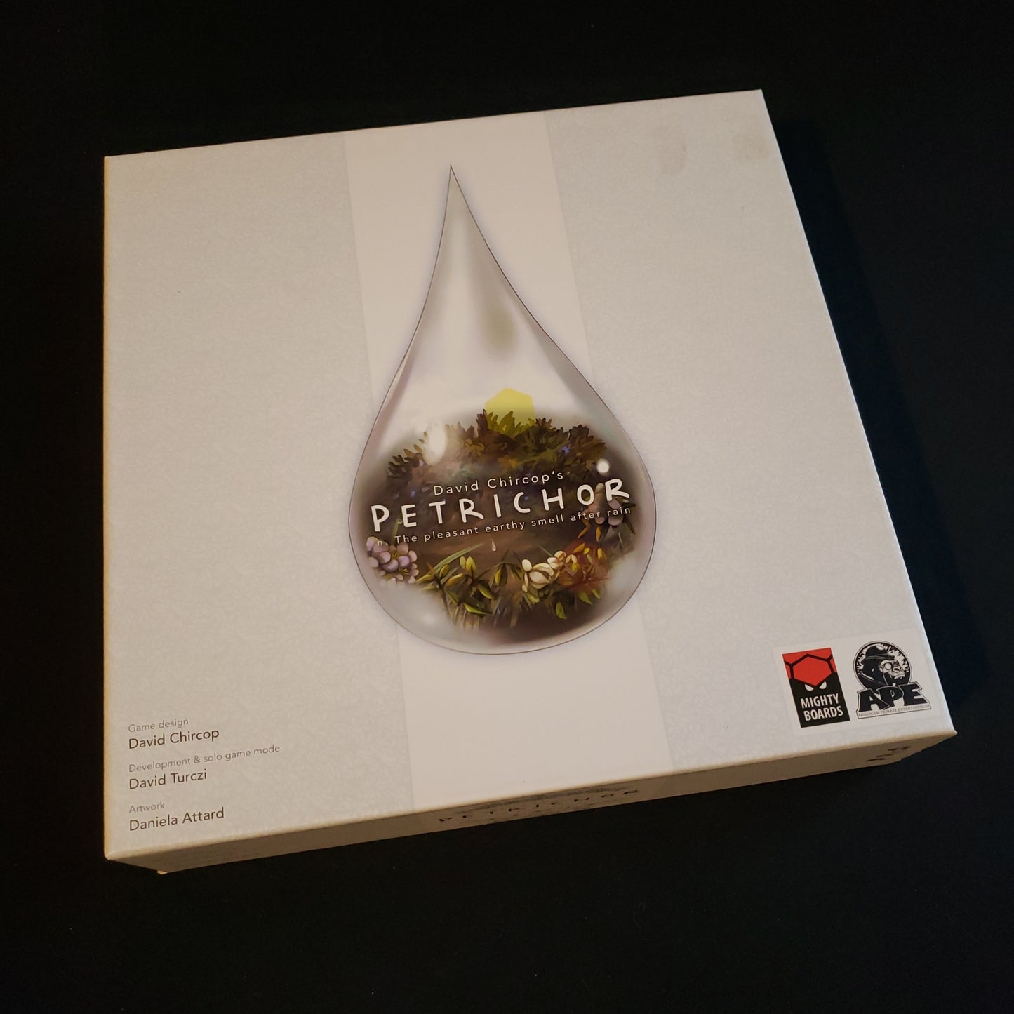 Image shows the front cover of the box of the Petrichor board game