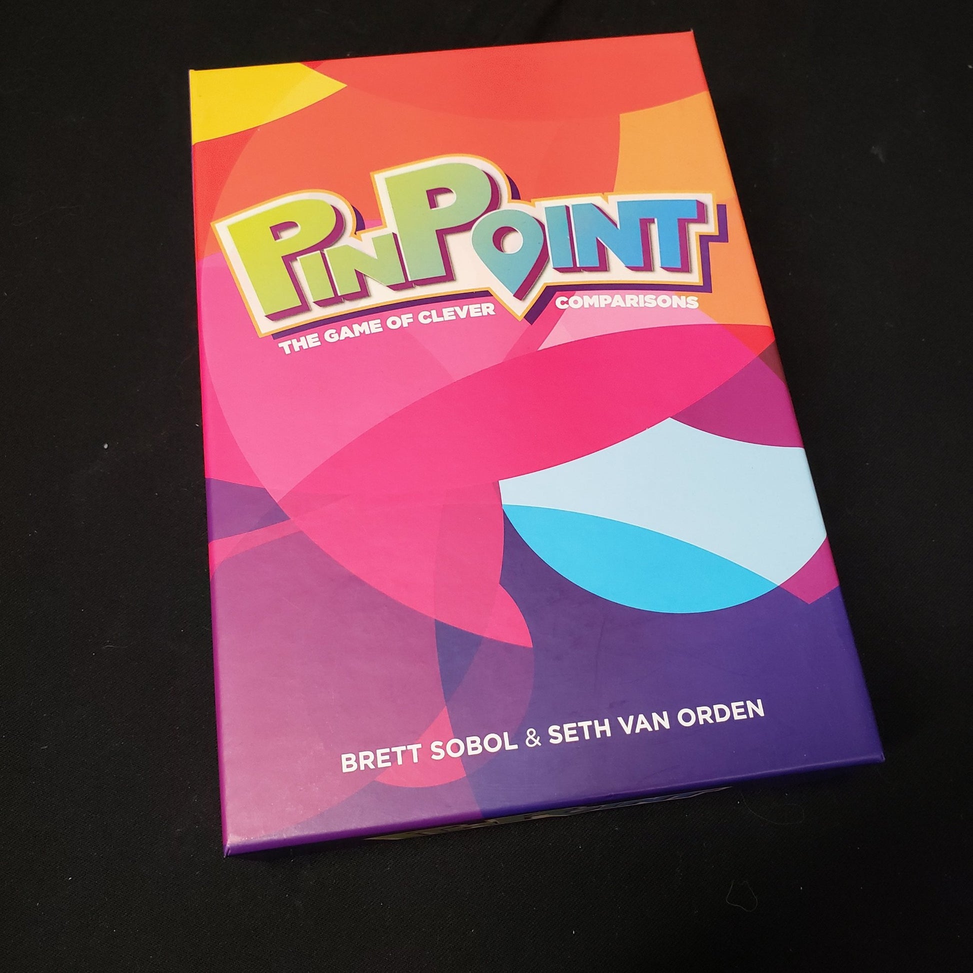 Image shows the front cover of the box of the Pinpoint board game