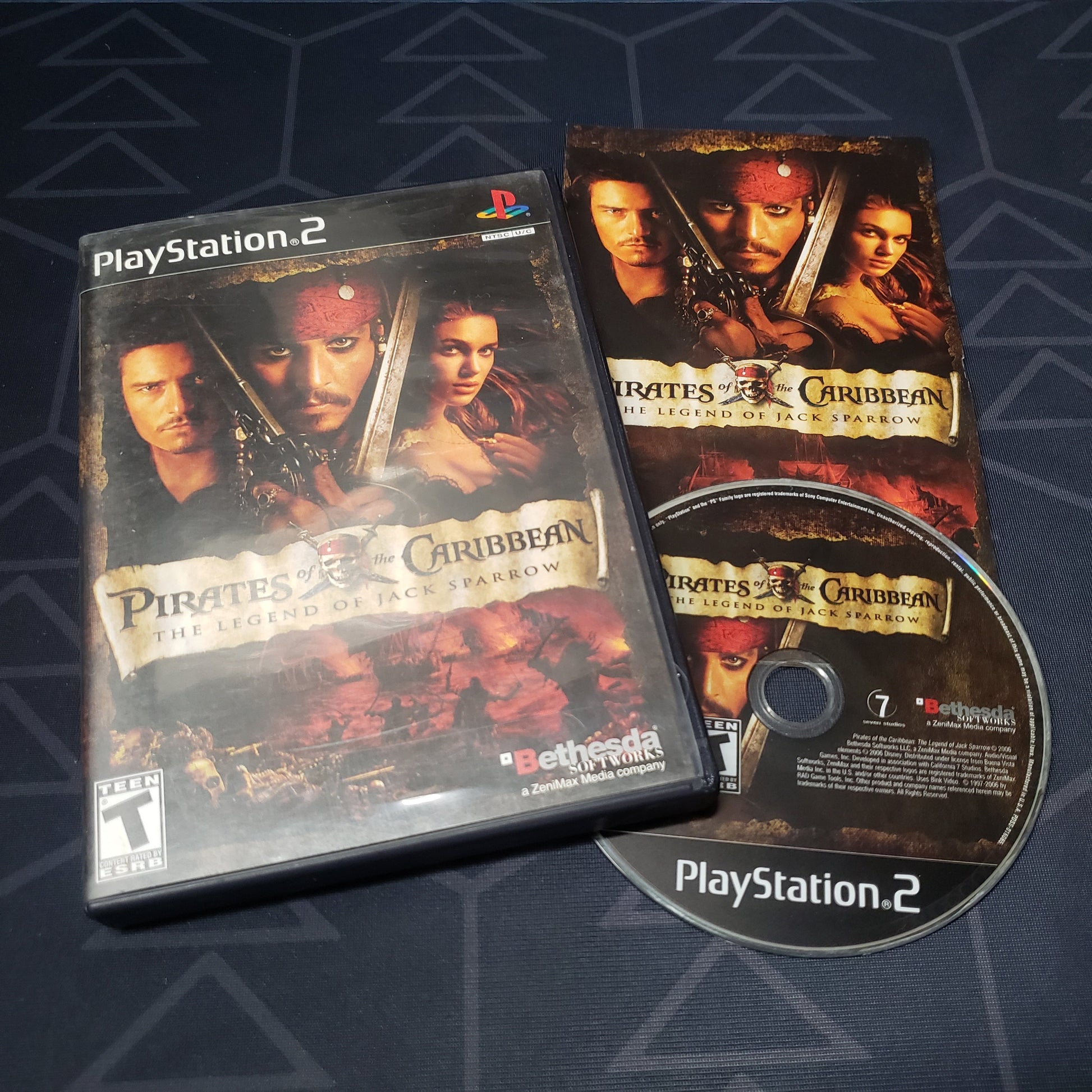 Image shows the case, manual and disc for the video game Pirates of the Caribbean: The Legend of Jack Sparrow for Playstation 2