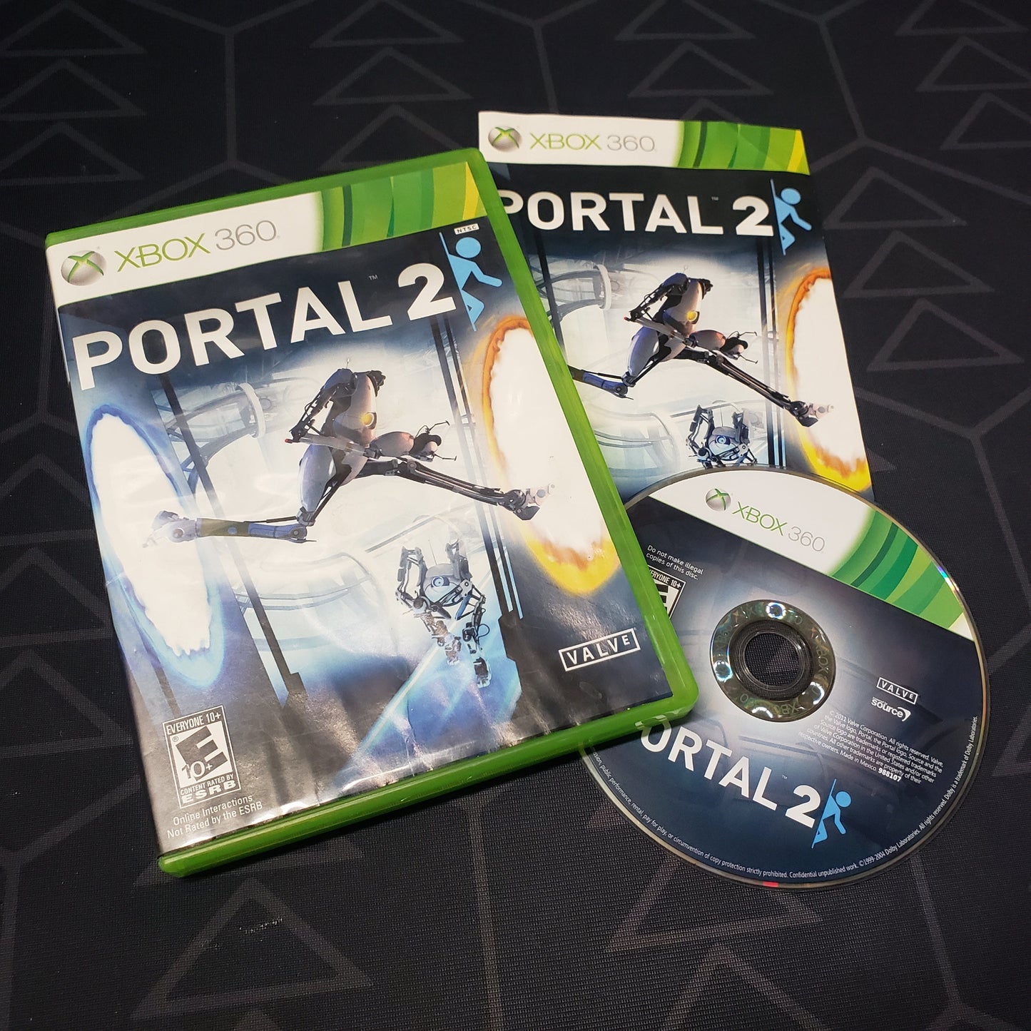 Image shows the case, manual and disc for the video game Portal 2 for Xbox 360