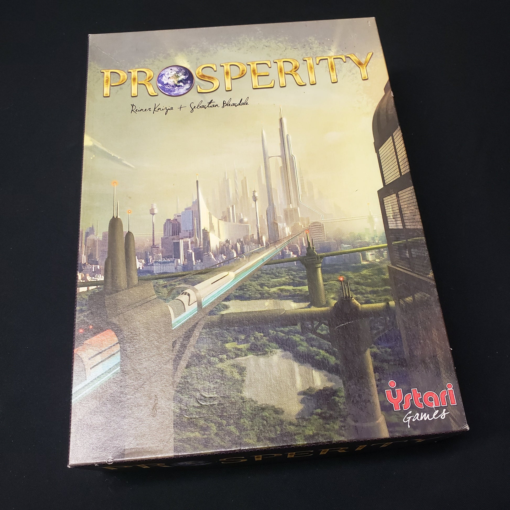 Image shows the front cover of the box of the Prosperity board game