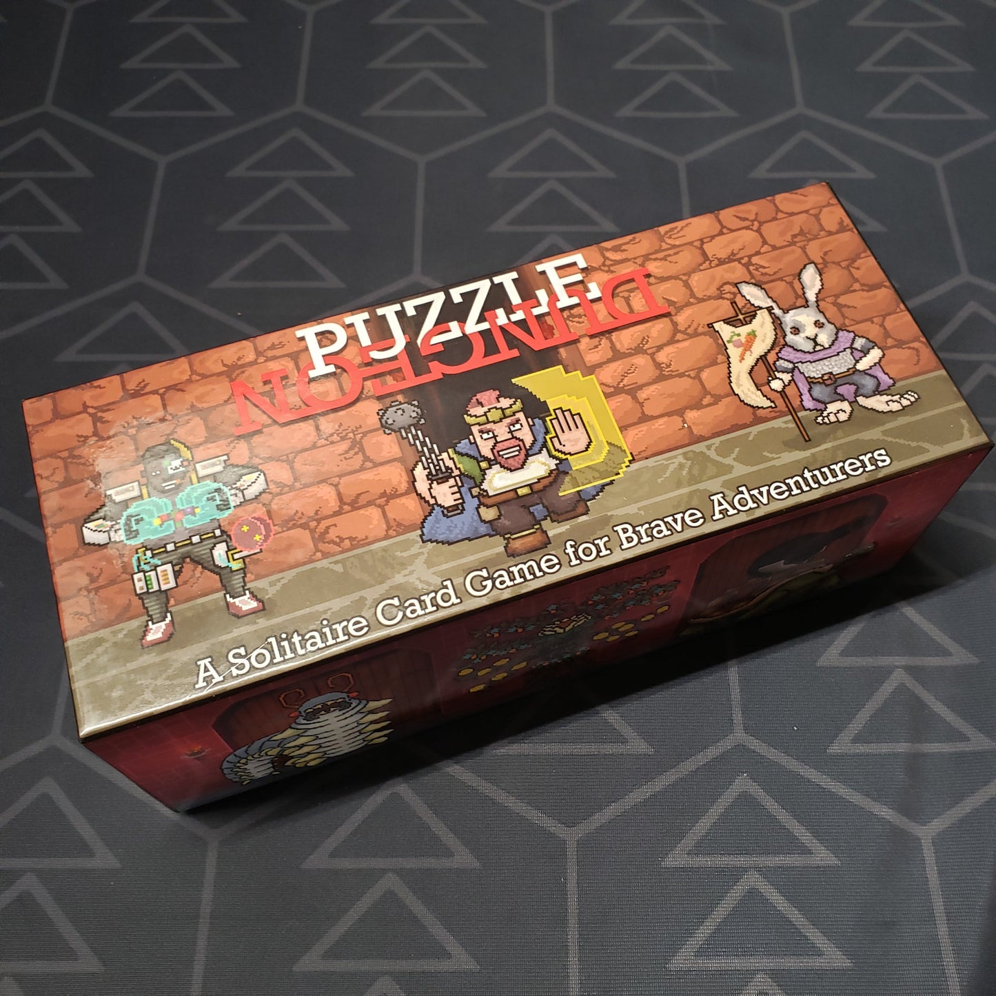 Image shows the front cover of the box for the Puzzle Dungeon (Deluxe Edition) card game