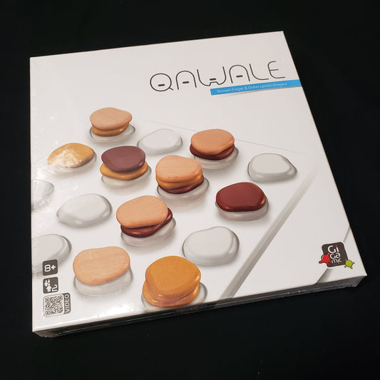 Image shows the front cover of the box of the Qawale board game