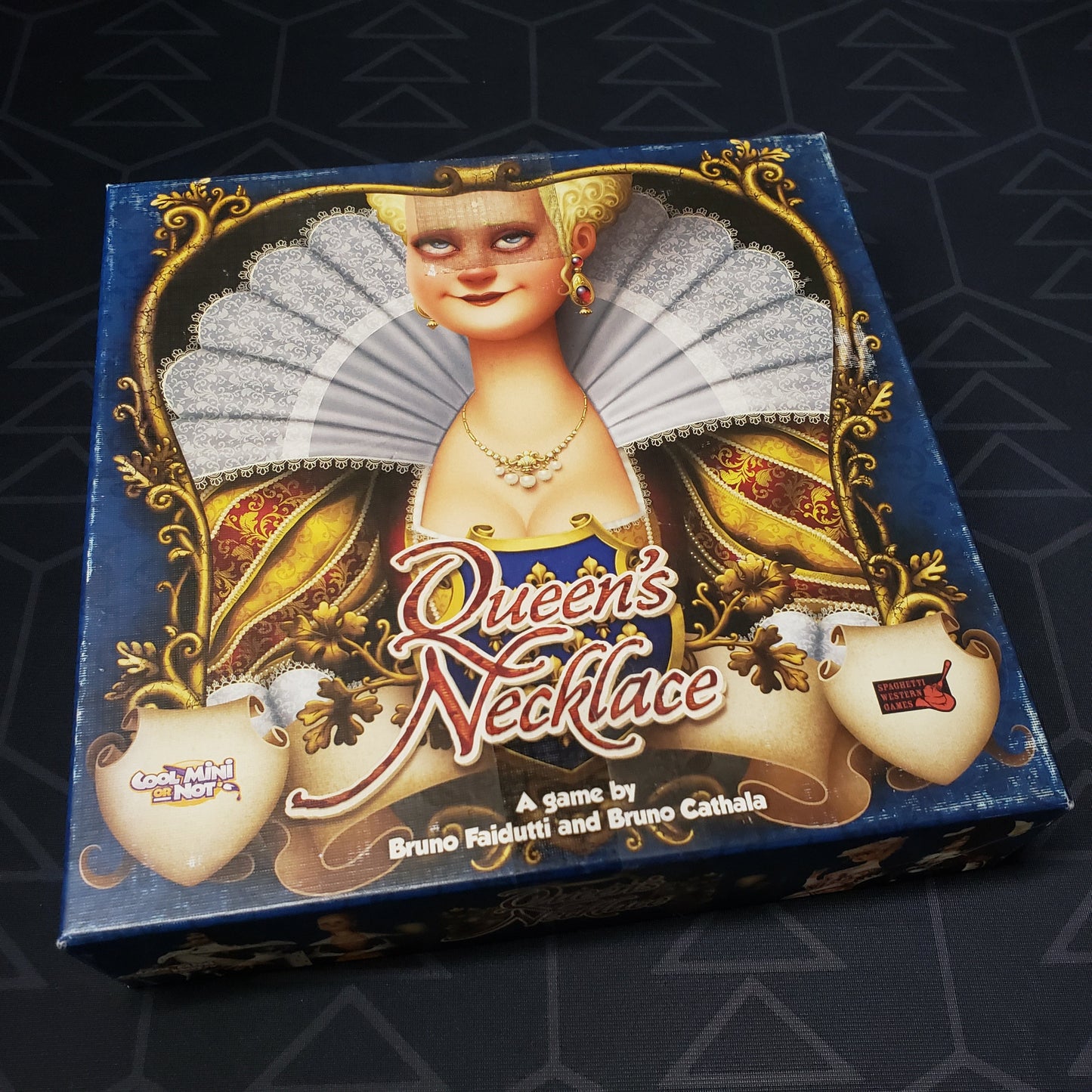 Image shows the front cover of the box of the Queen's Necklace card game