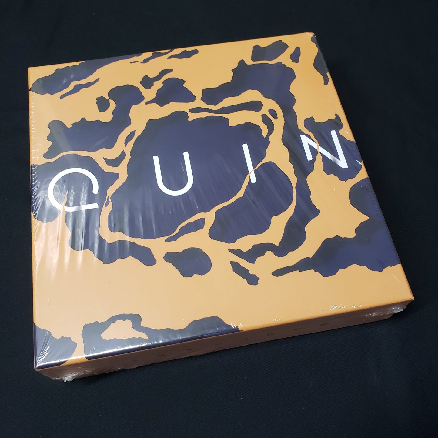 Image shows the front cover of the box of the Quin board game