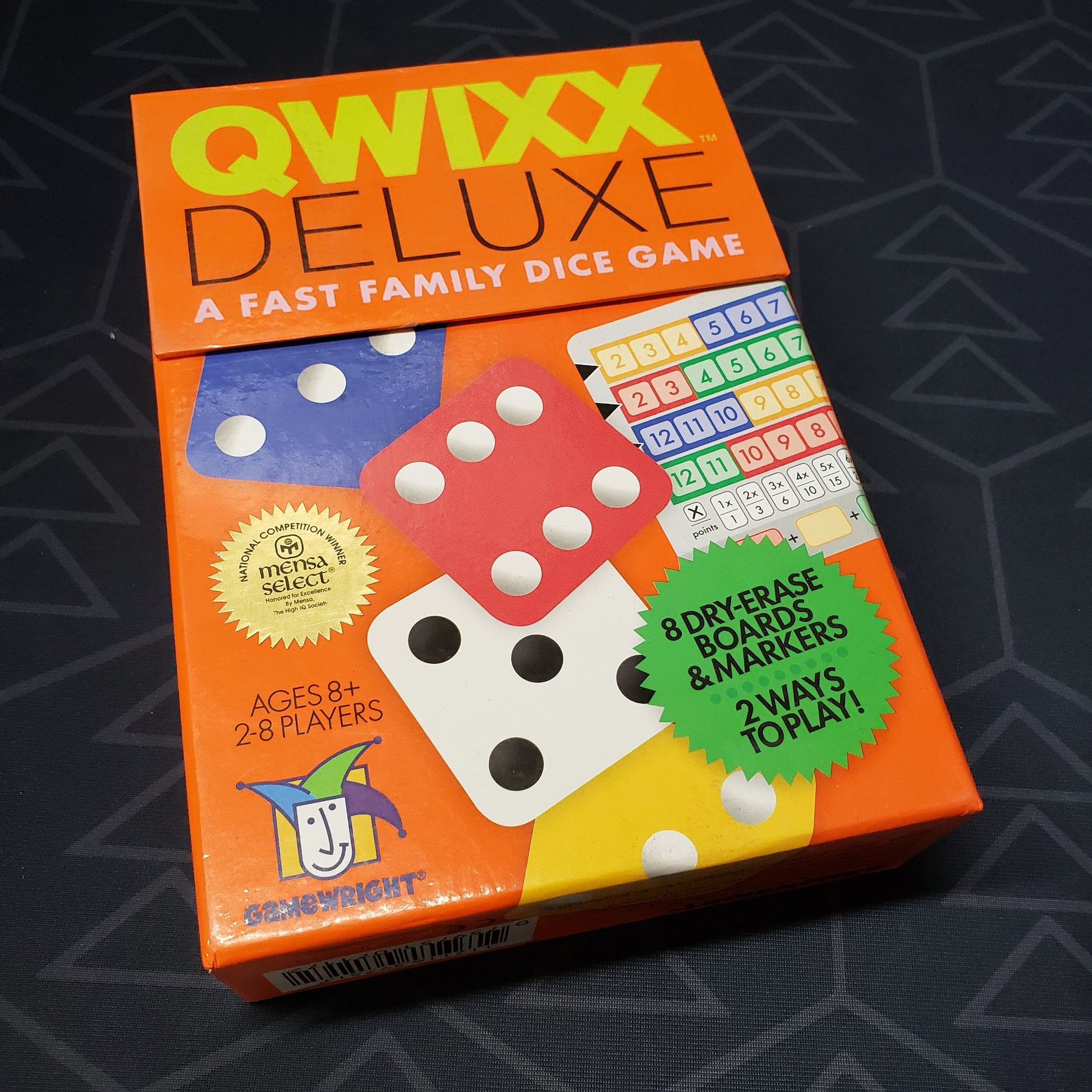 Image shows the front cover of the box for the Qwixx Deluxe board game