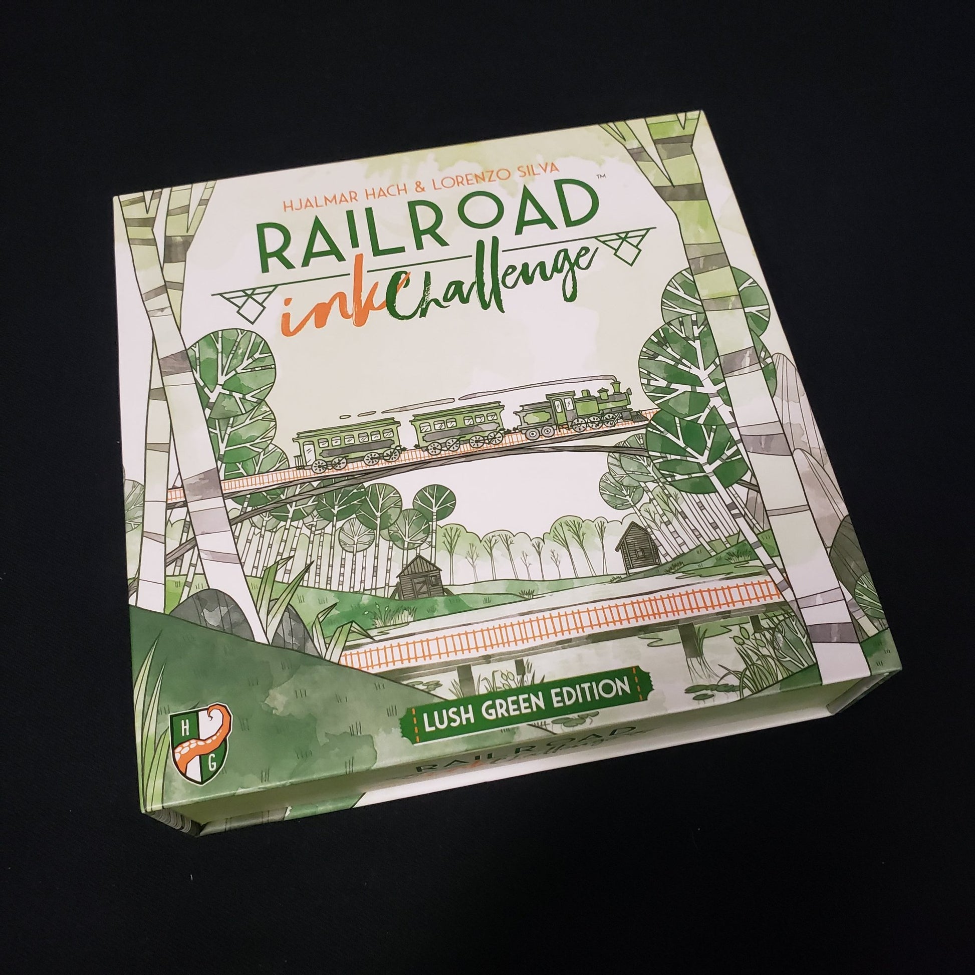 Image shows the front cover of the box of the board game Railroad Ink Challenge: Lush Green Edition