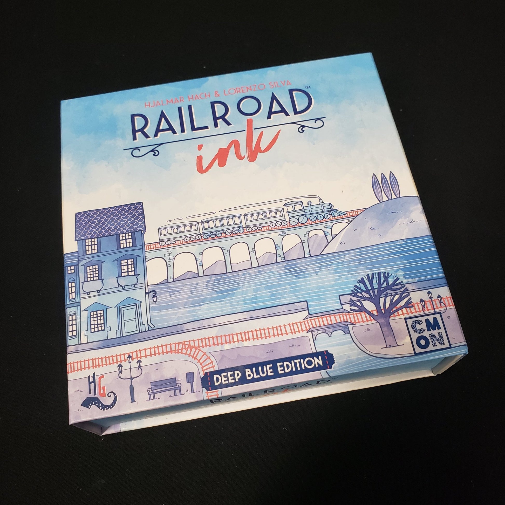Image shows the front cover of the box of the board game Railroad Ink: Deep Blue Edition