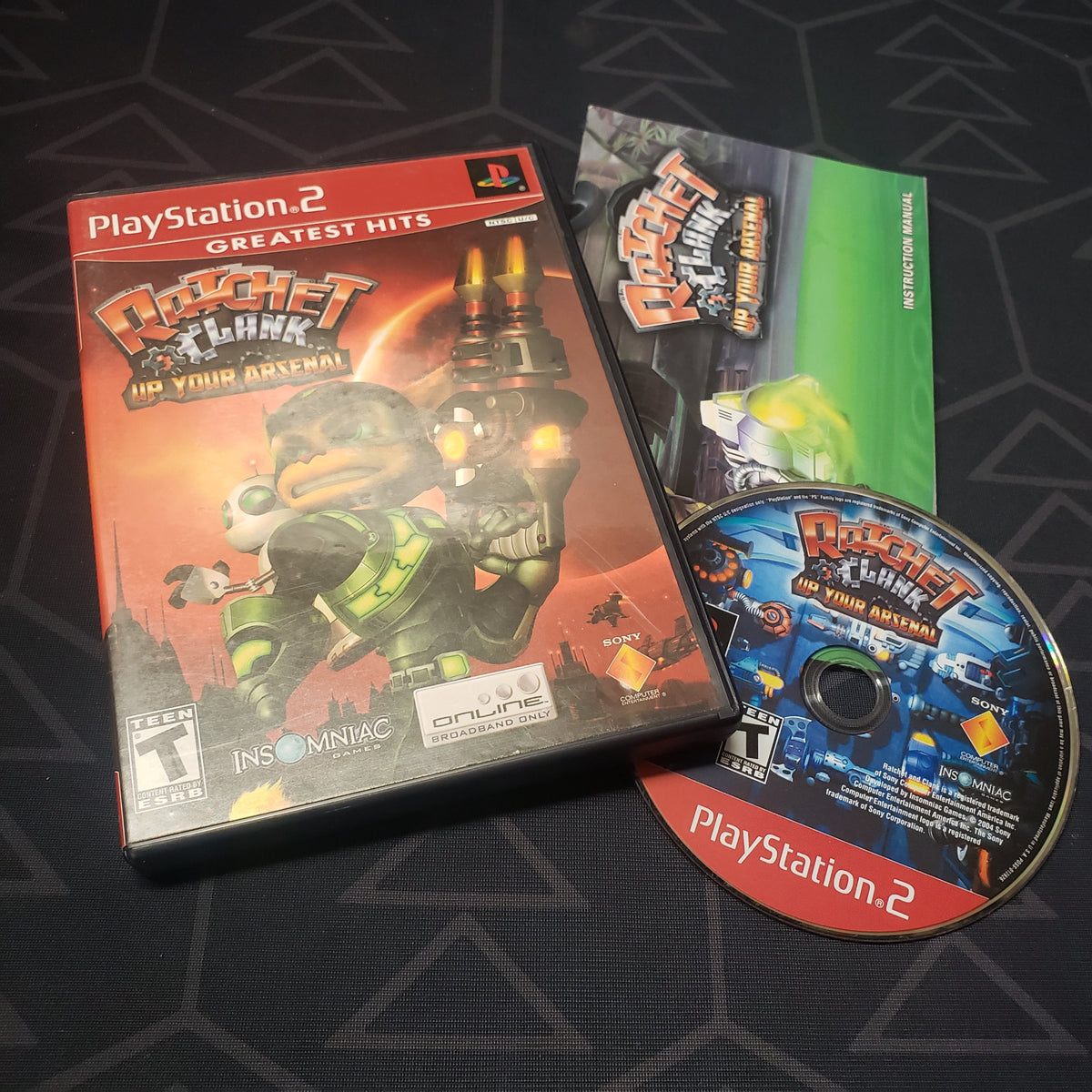 Image shows the case, manual and disc for the video game Ratchet & Clank: Up Your Arsenal for Playstation 2