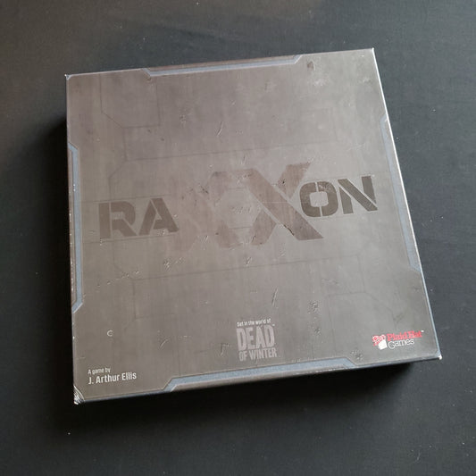 Image shows the front cover of the box of the Raxxon board game