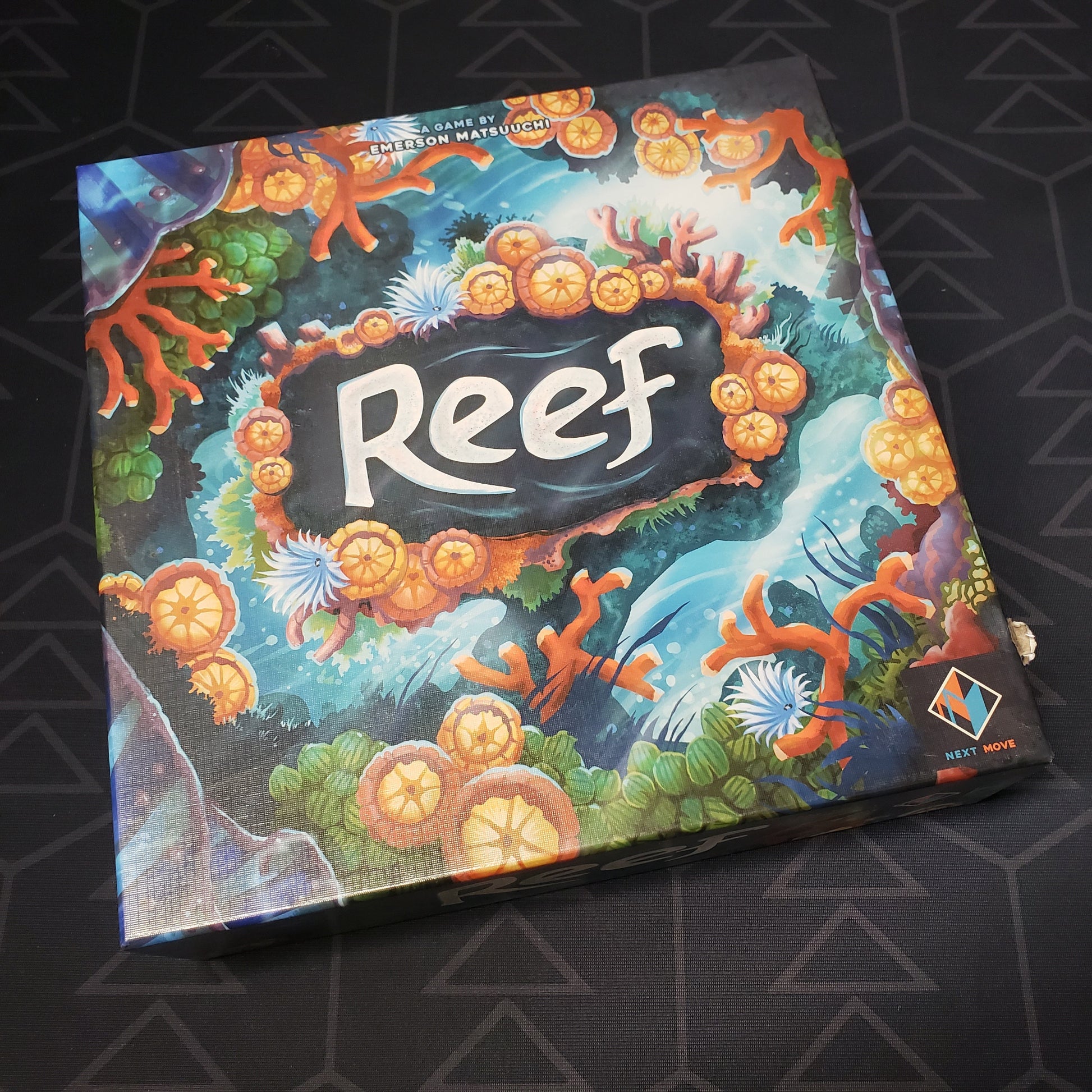 Image shows the front cover of the box of the Reef board game