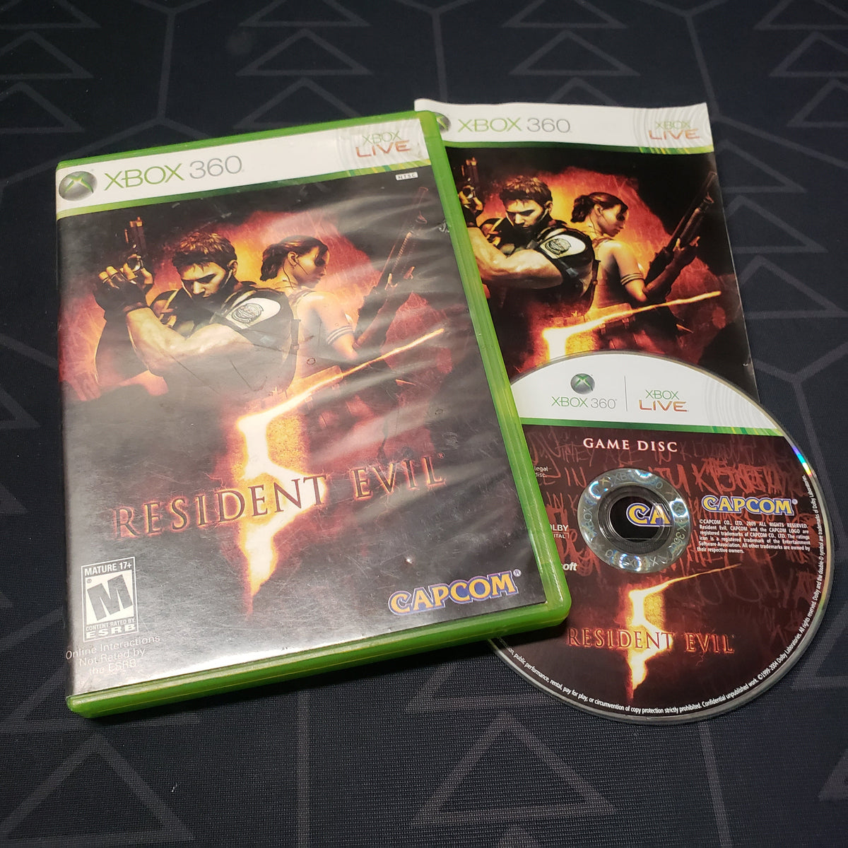 Image shows the case, manual and disc for the video game Resident Evil 5 for Xbox 360