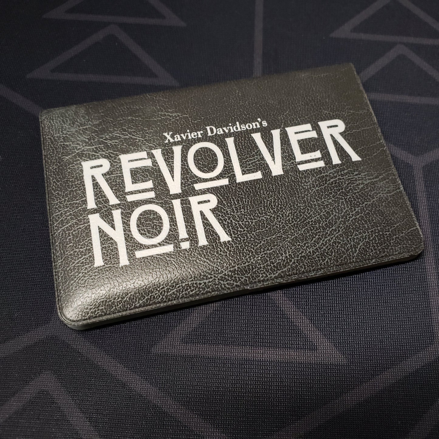 Image shows the front of the card wallet of the card game Revolver Noir