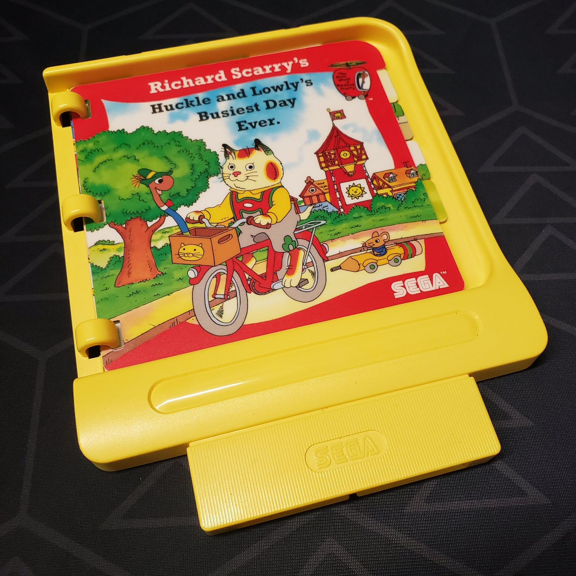 Image shows the front of the book cartridge for the video game Richard Scarry's Huckle and Lowly's Busiest Day Ever for Sega Pico