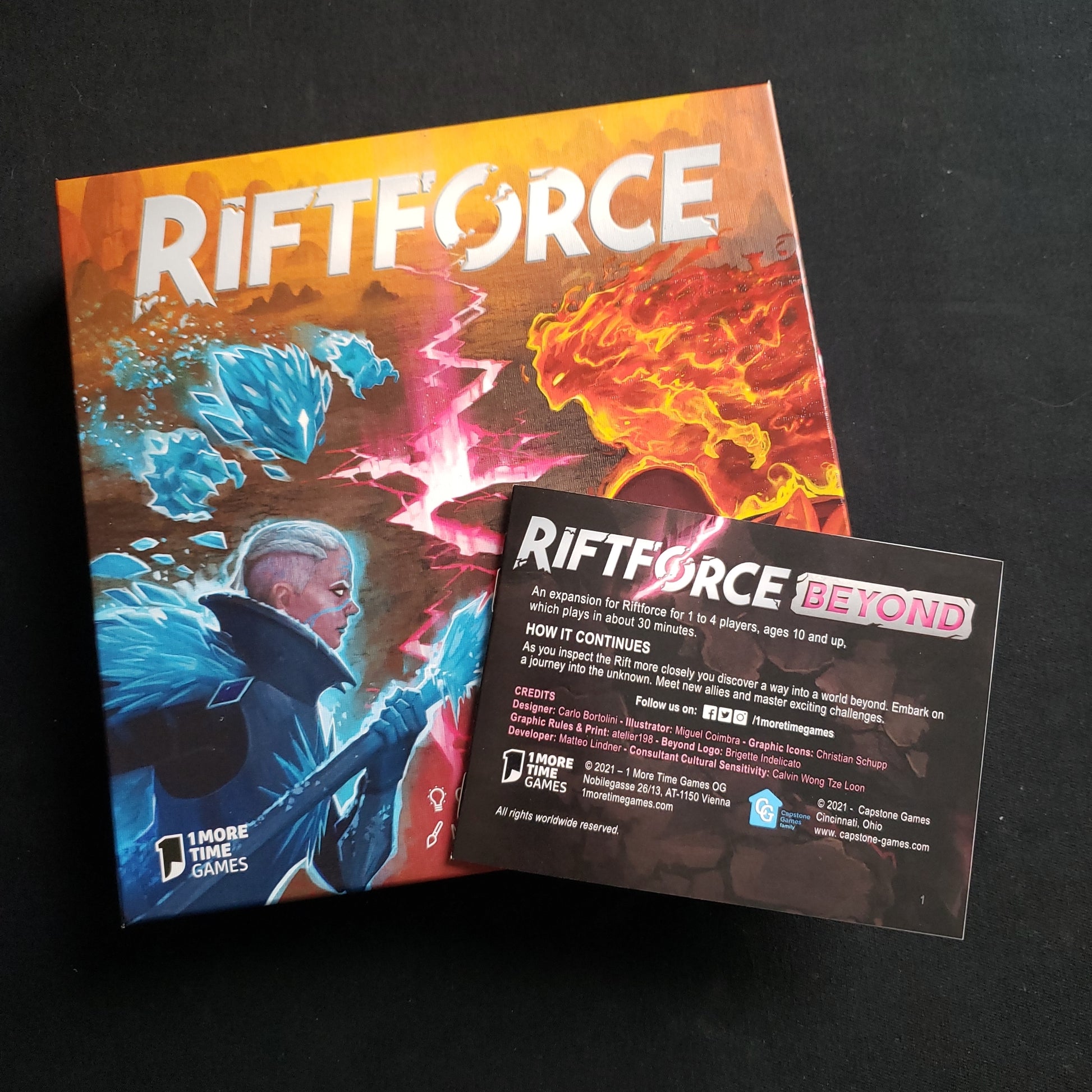 Image shows the front cover of the box of the Riftforce card game, with the instructions for the Beyond expansion sitting on top of it