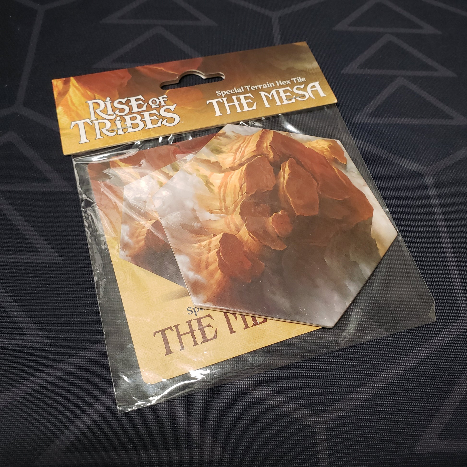 Image shows the front of the package of the Mesa expansion tile for the board game Rise of Tribes
