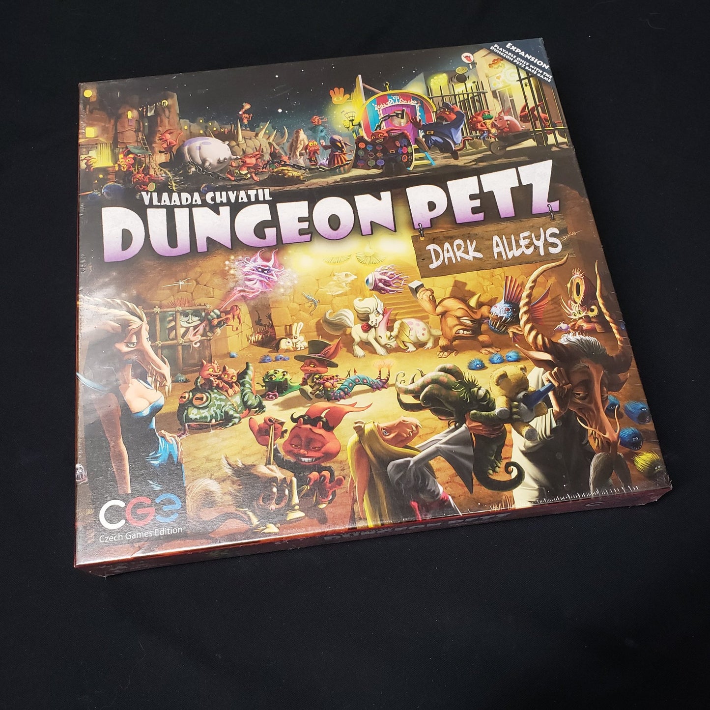 Image shows the front cover of the box of the Dark Alleys expansion for the board game Dungeon Petz