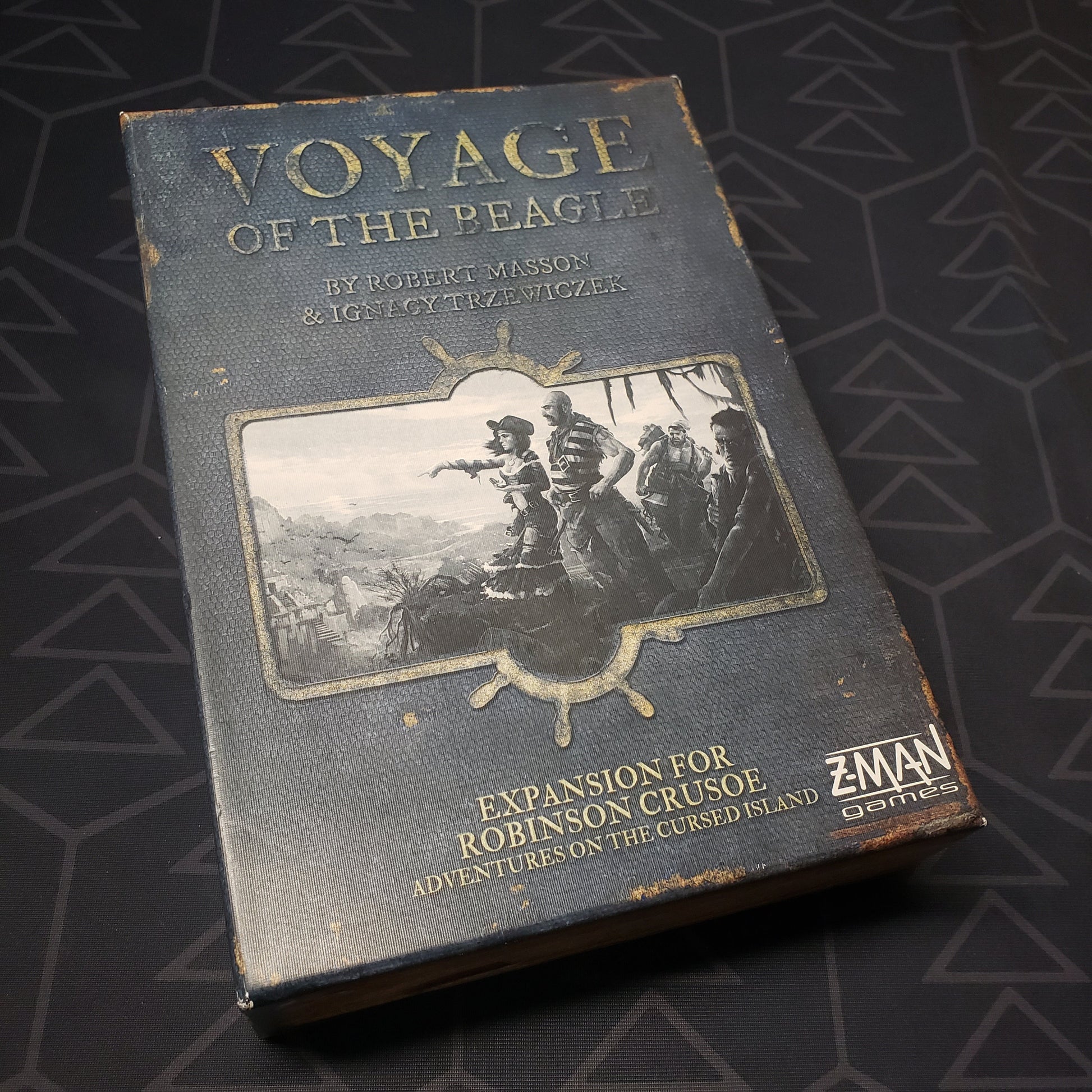 Image shows the front cover of the box of the Voyage of the Beagle expansion for the board game Robinson Crusoe