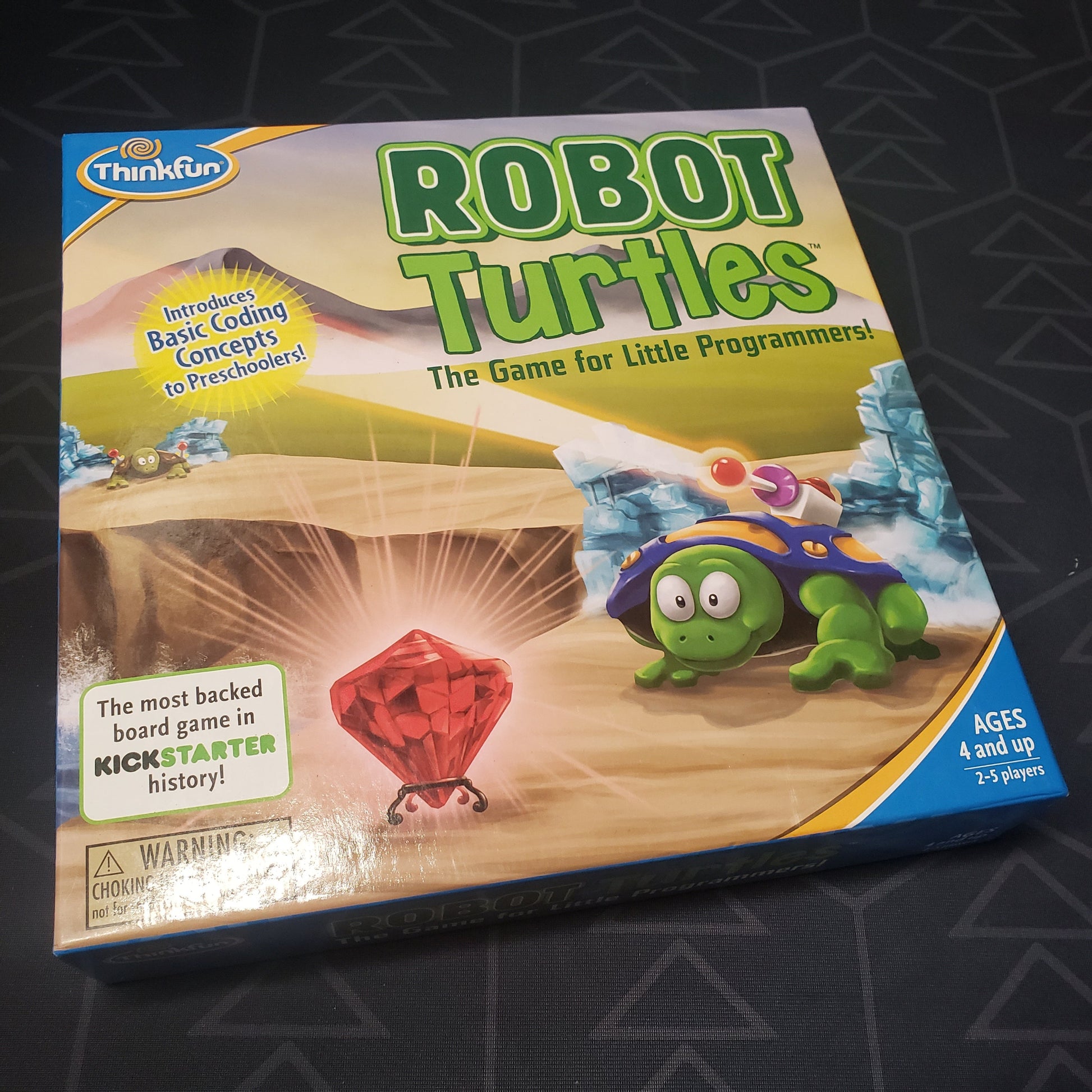 Image shows the front cover of the box for the Robot Turtles board game