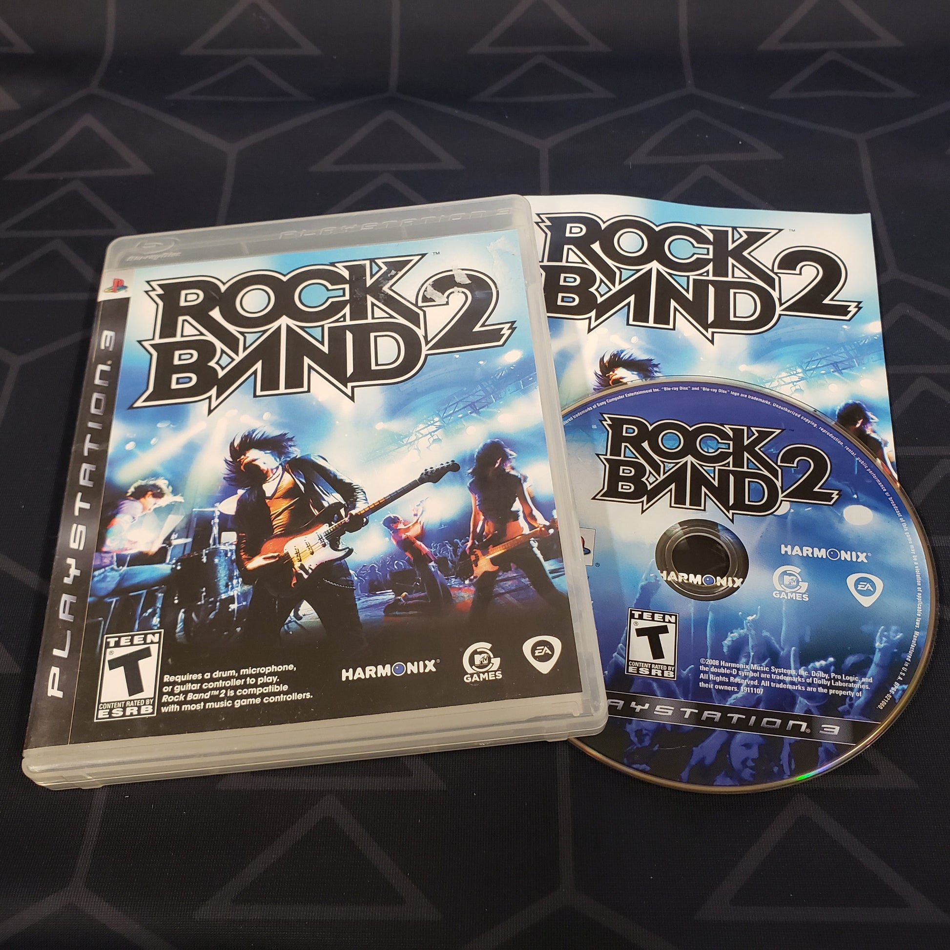 Image shows the case, manual and disc for the video game Rock Band 2 for Playstation 3