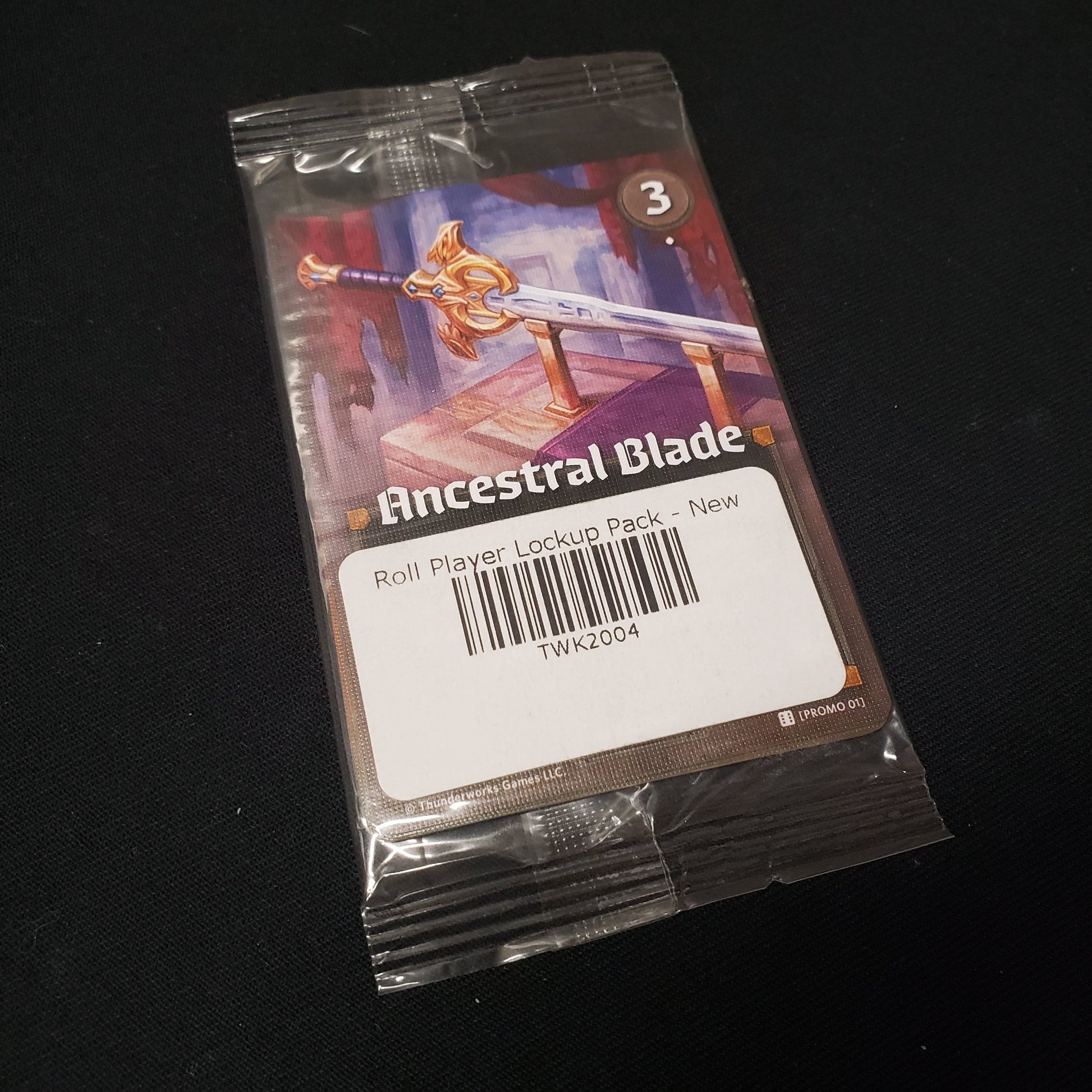 Image shows a card inside the clear plastic packaging of the Lockup Pack for the board game Roll PLayer