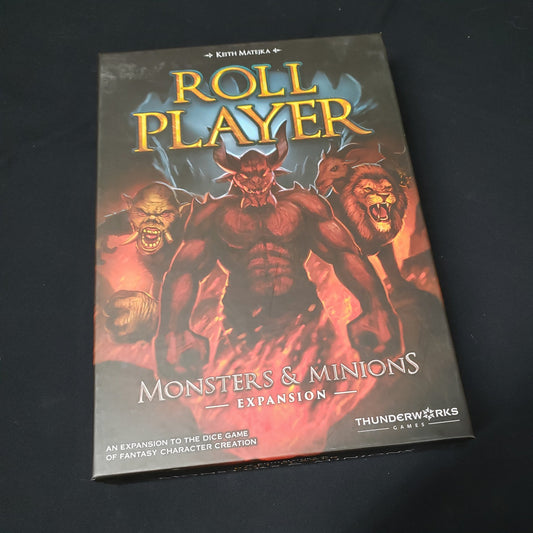 Image shows the front cover of the box of the Monsters & Minions expansion for the board game Roll Player