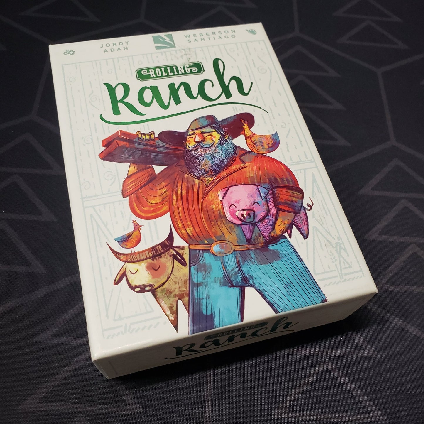 Image shows the front cover of the box of the Rolling Ranch board game