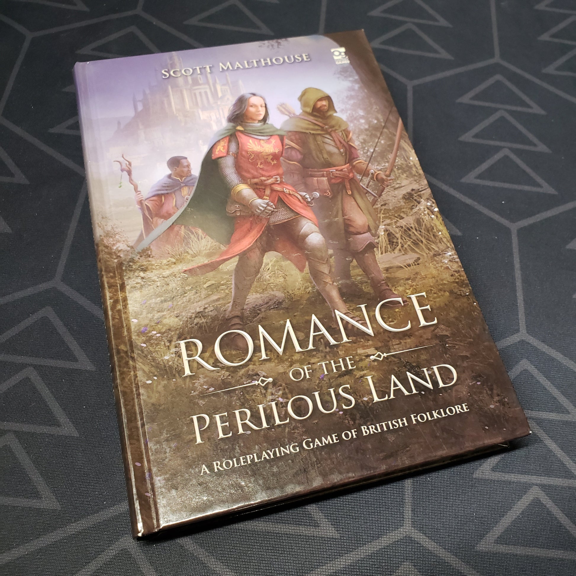 Image shows the front cover of the core rulebook for the roleplaying game Romance of the Perilous Land