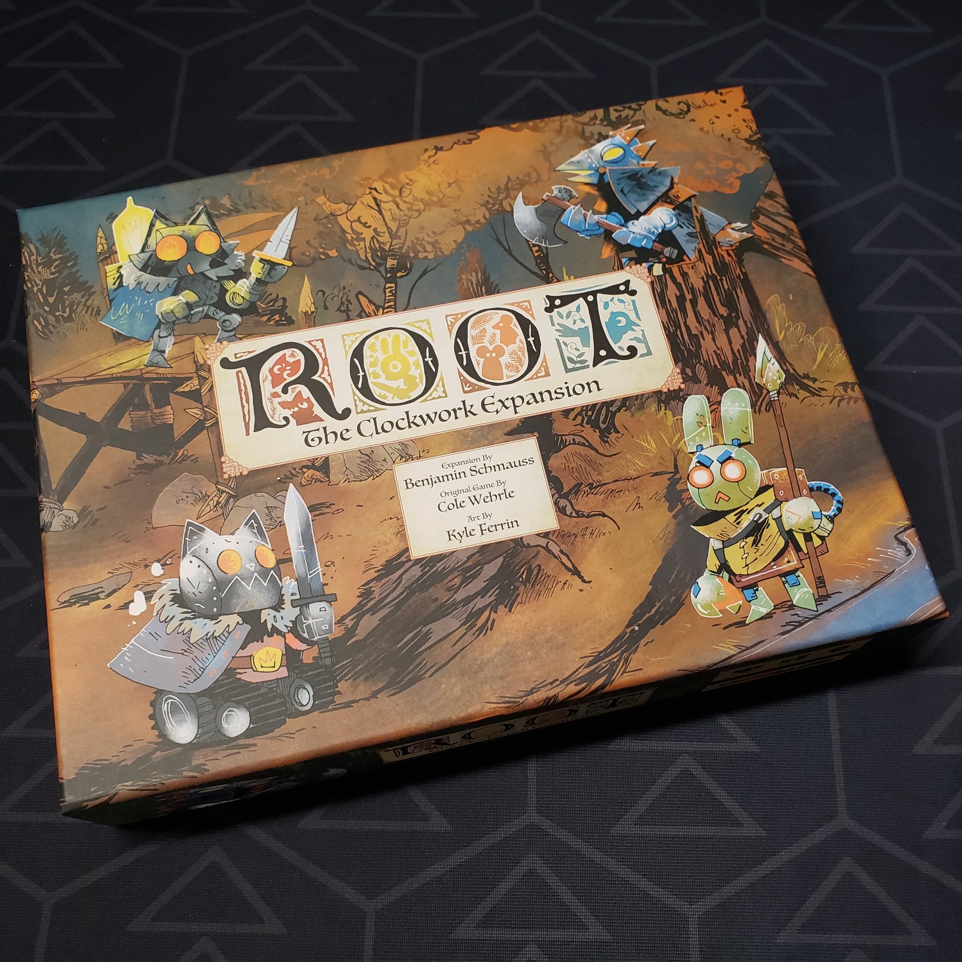 Image shows the front cover of the box for the Clockwork expansion from the board game Root