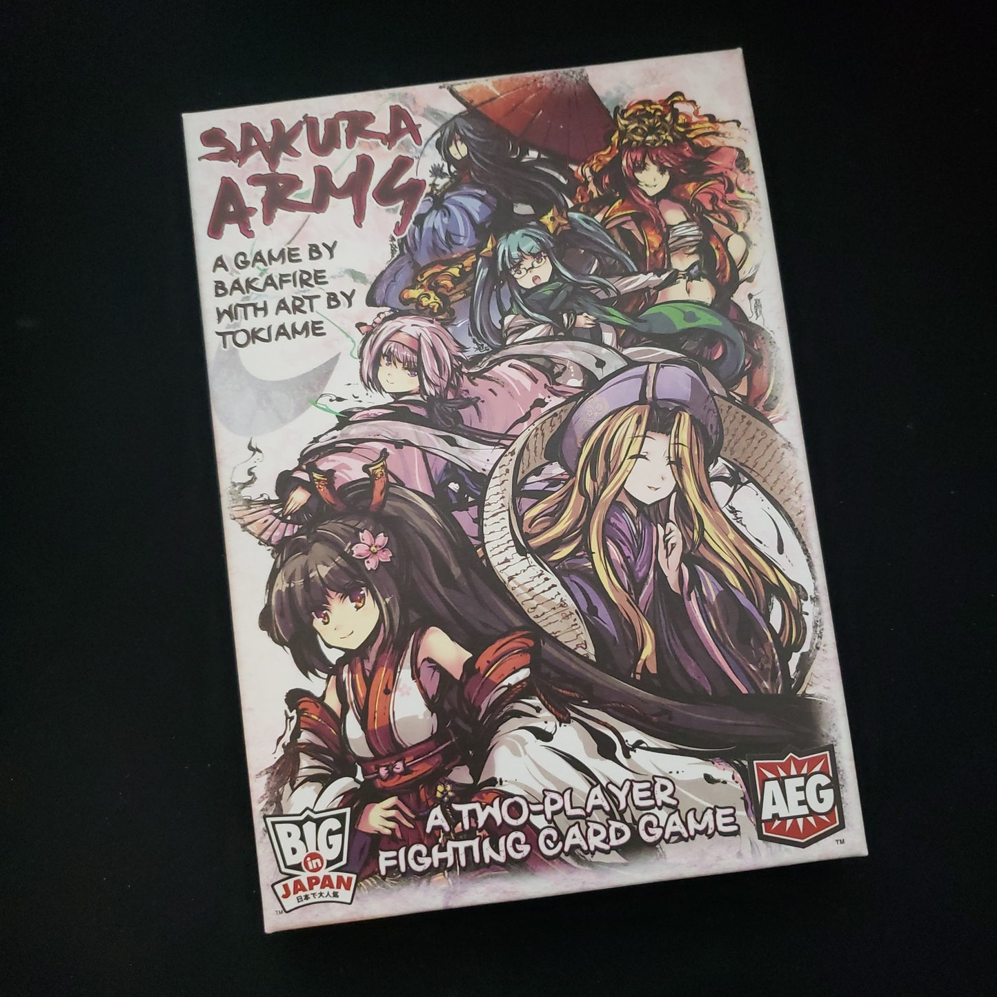 Image shows the front cover of the box of the Sakura Arms card game