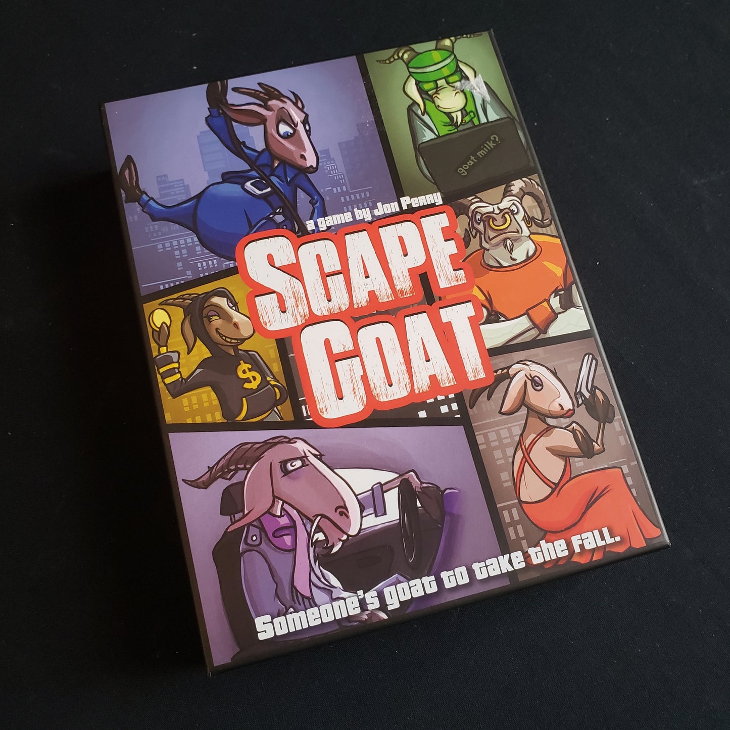 Image shows the front cover of the box of the Scape Goat card game