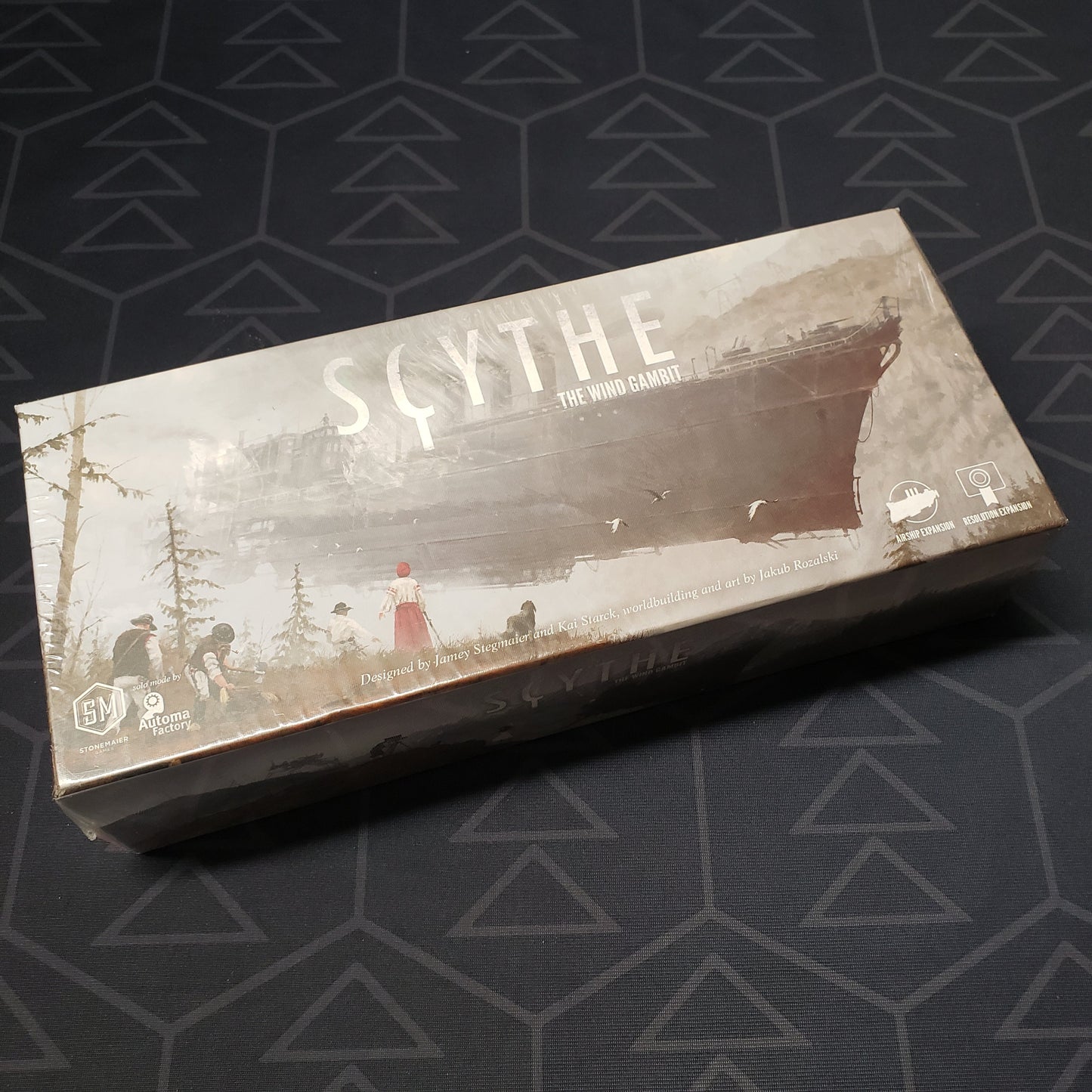 Image shows the front cover of the box of the Wind Gambit expansion for the board game Scythe
