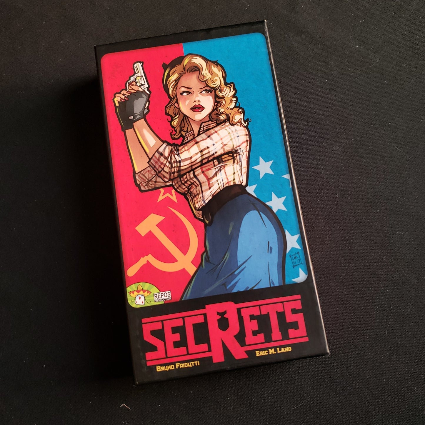 Image shows the front cover of the box of the Secrets card game
