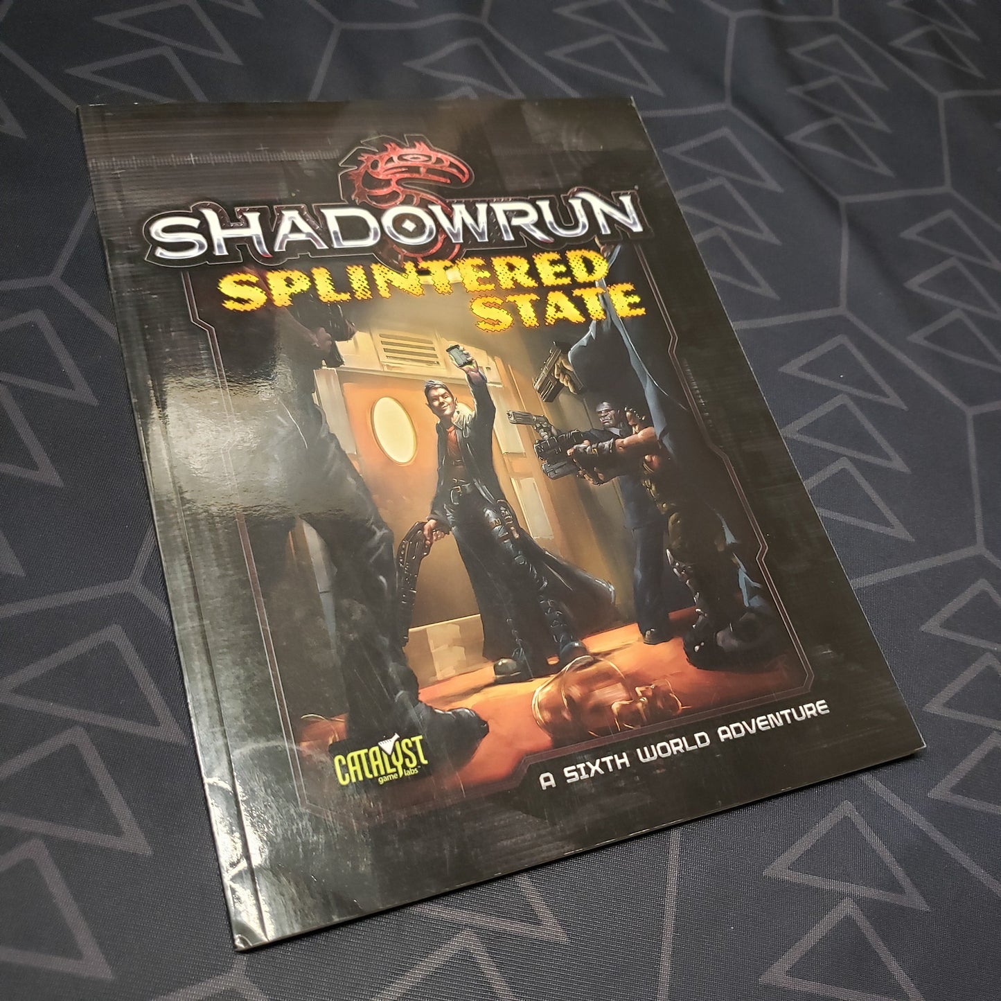 Image shows the front cover of the Splintered State book for the roleplaying game Shadowrun 5E