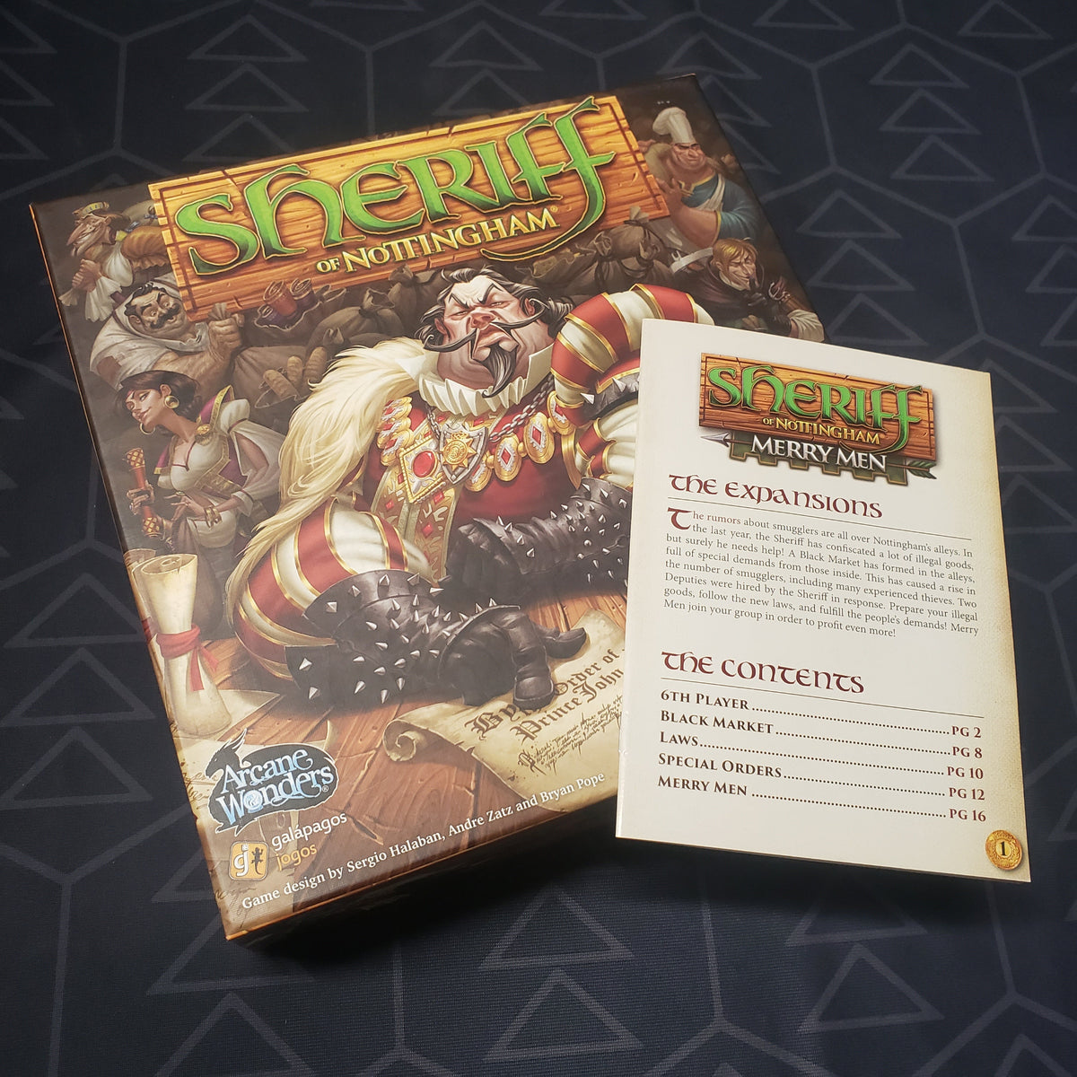 Image shows the front cover of the box of the Sheriff of Nottingham board game with the instructions for the Merry Men expansion sitting on top of it