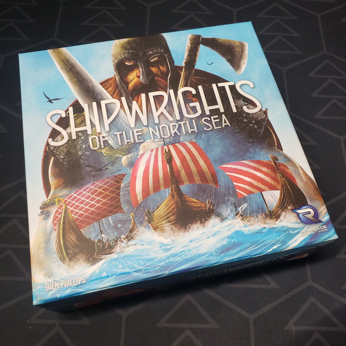 Image shows the front cover of the box of the Shipwrights of the North Sea board game