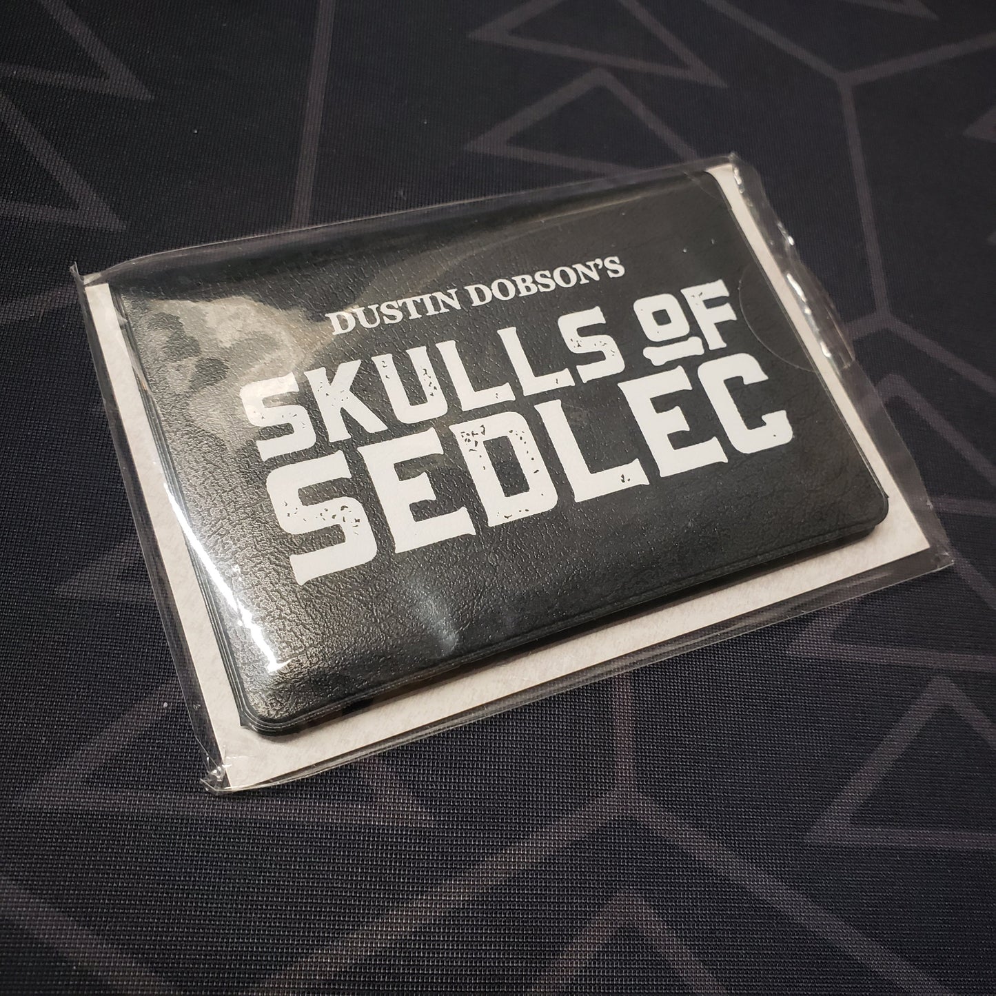 Image shows the front cover of the card wallet of the Skulls of Sedlec card game