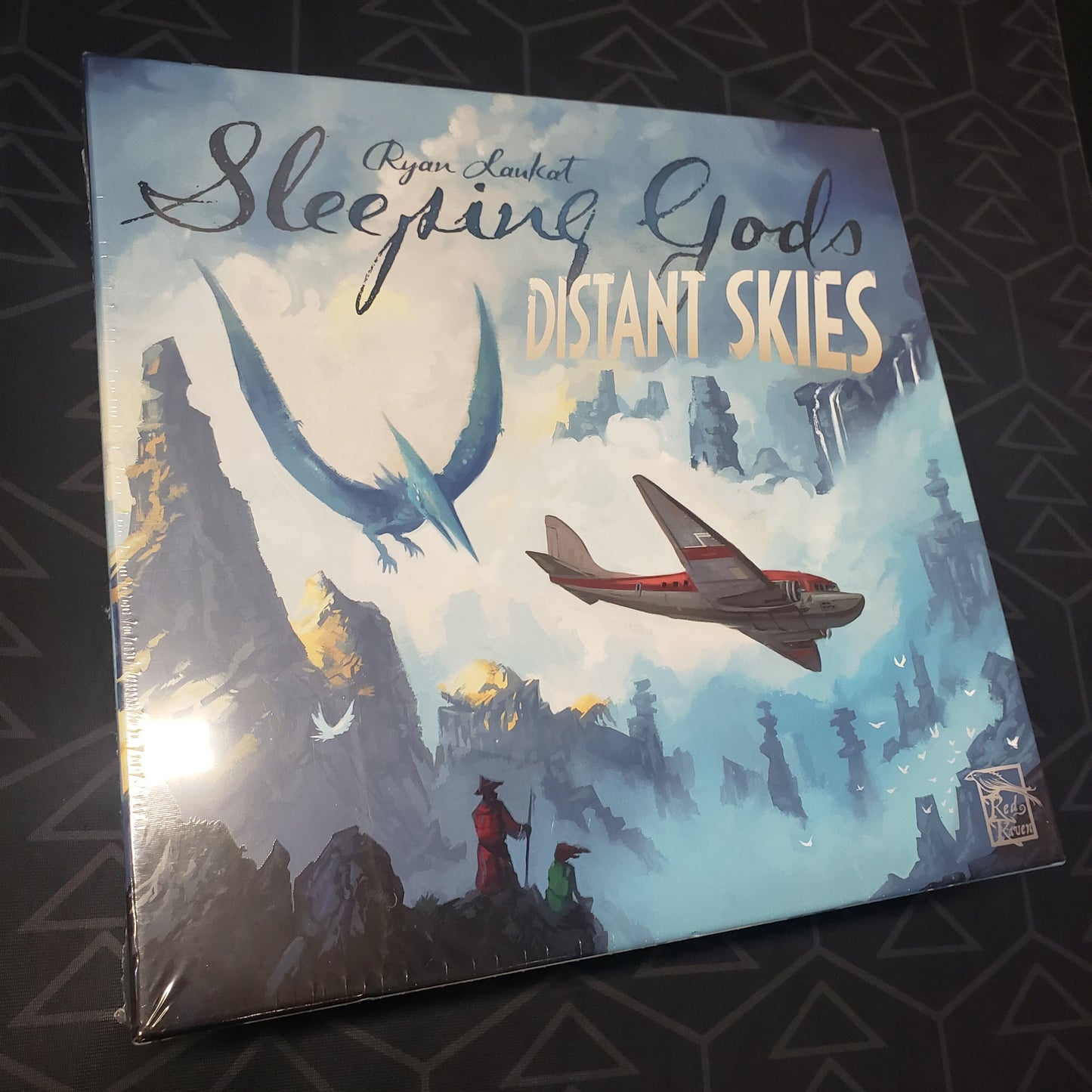 Image shows the front cover of the box of the Sleeping Gods: Distant Skies board game