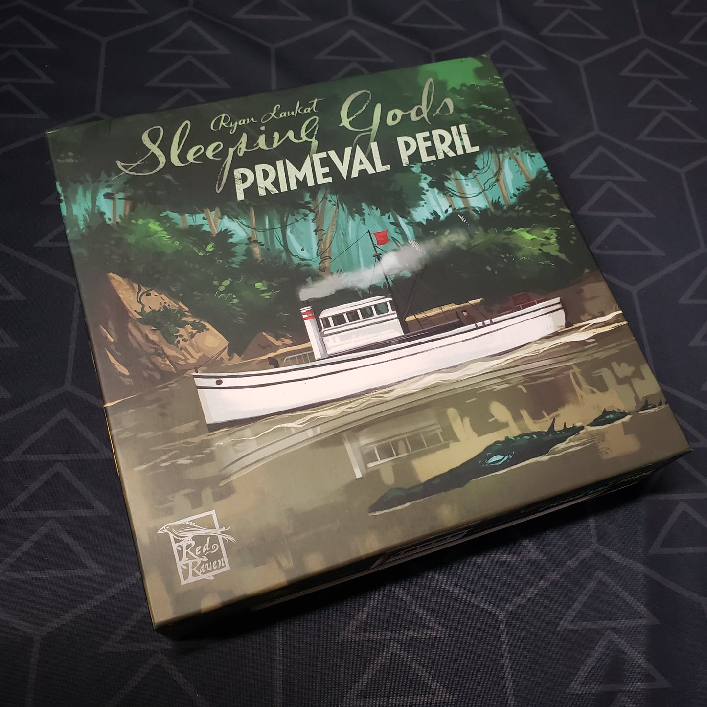 Image shows the front cover of the box for the Sleeping Gods: Primeval Peril board game