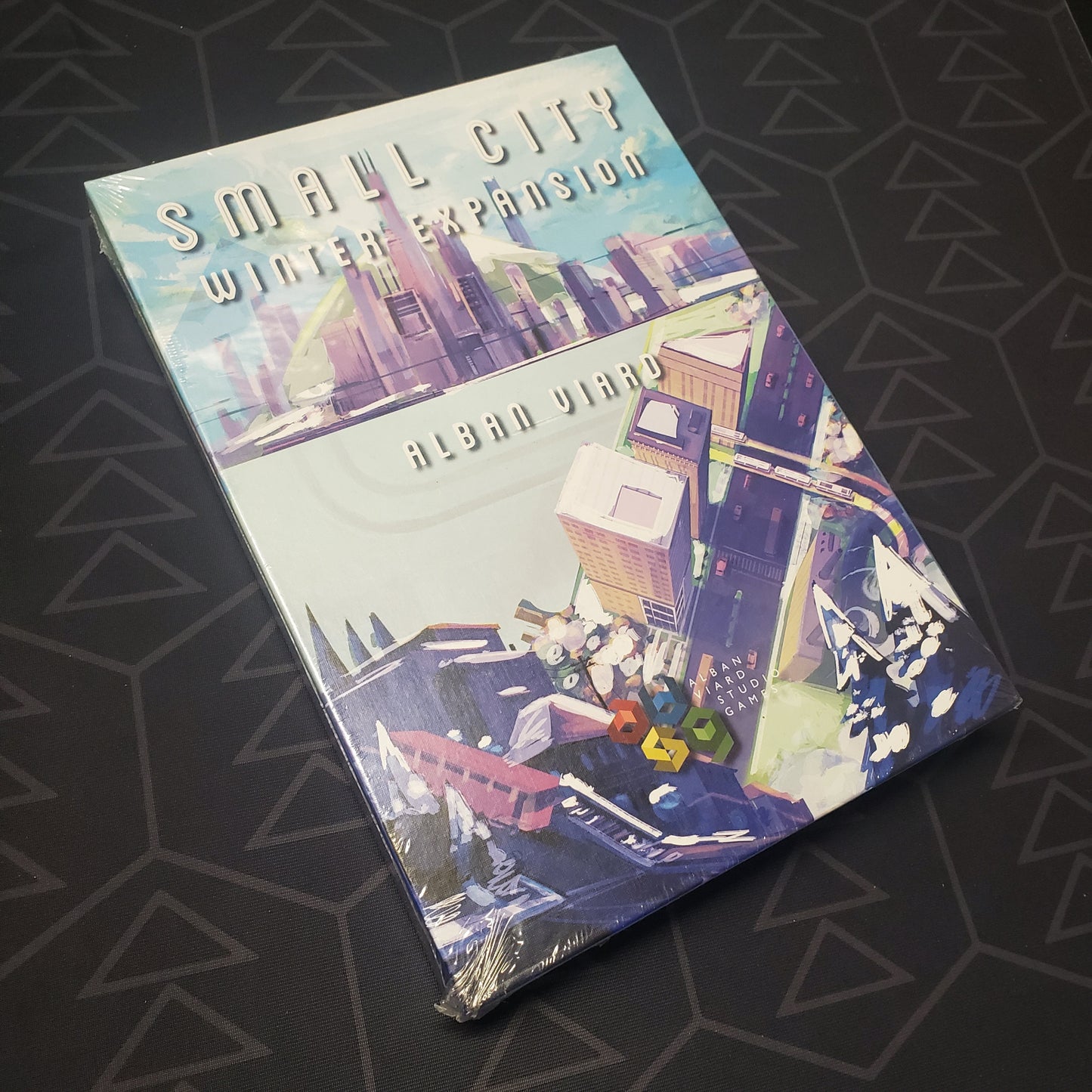 Image shows the front cover of the box of the Winter Expansion for the board game Small City: Deluxe Edition